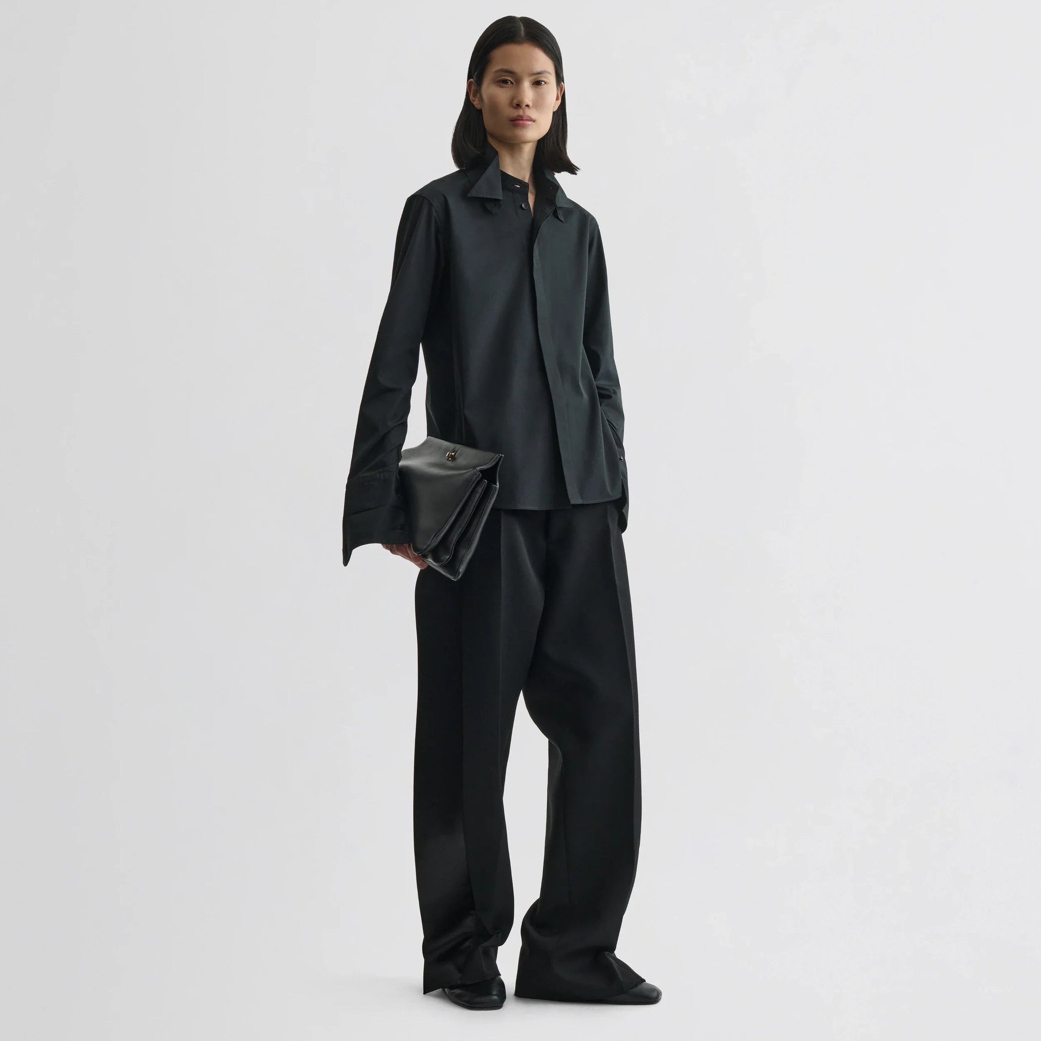 Front view of model wearing tuxedo shirt in black cotton.