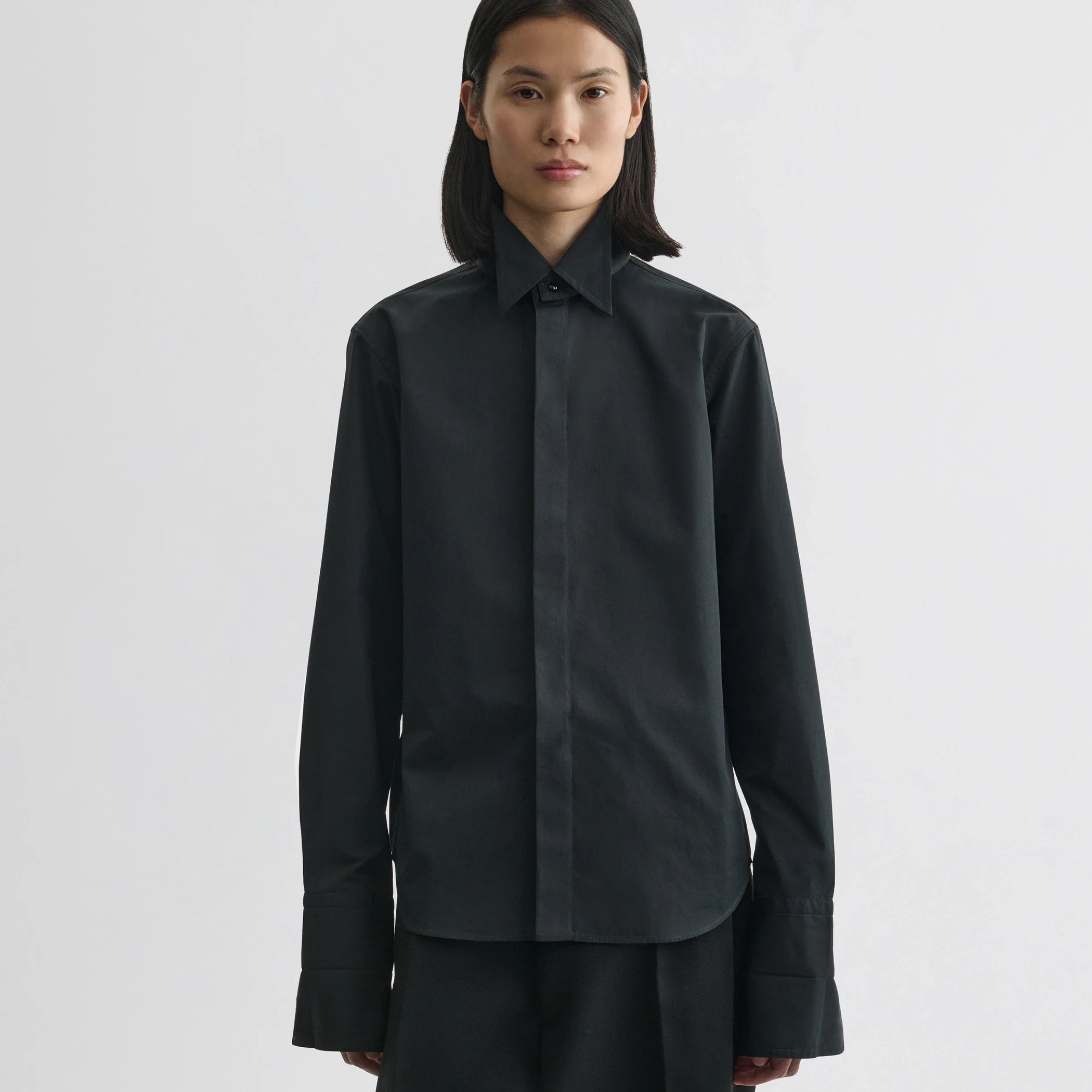 Front view of model wearing tuxedo shirt in black cotton.