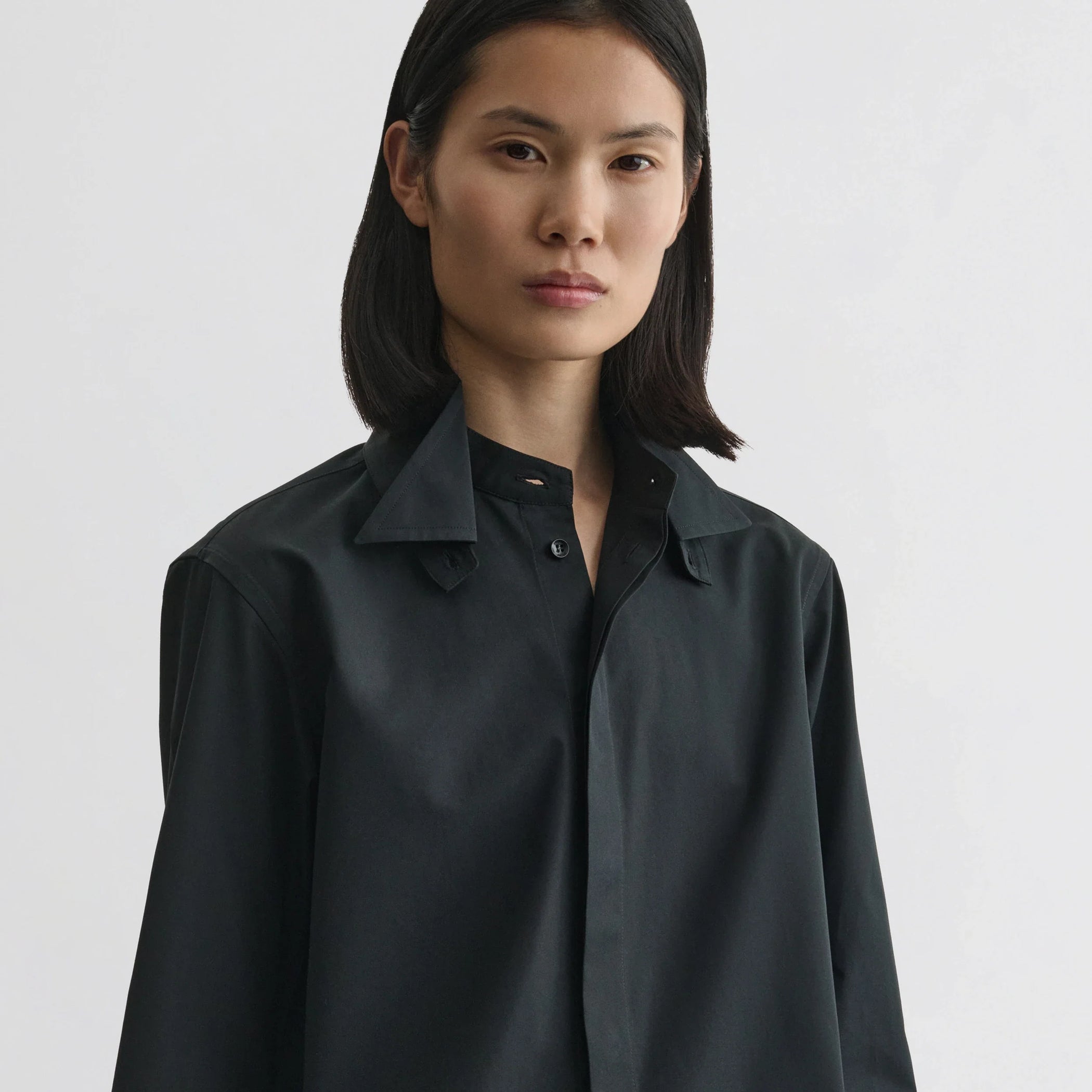 Front view of model wearing tuxedo shirt in black cotton.