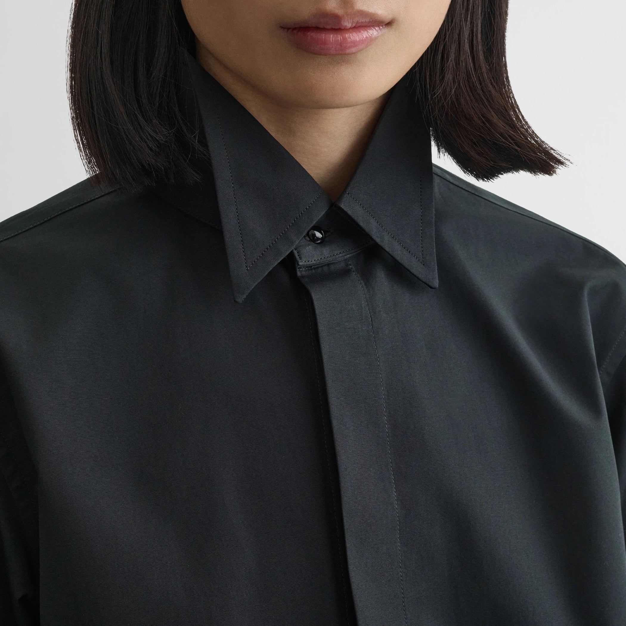Close up detail view of tuxedo shirt in black cotton.