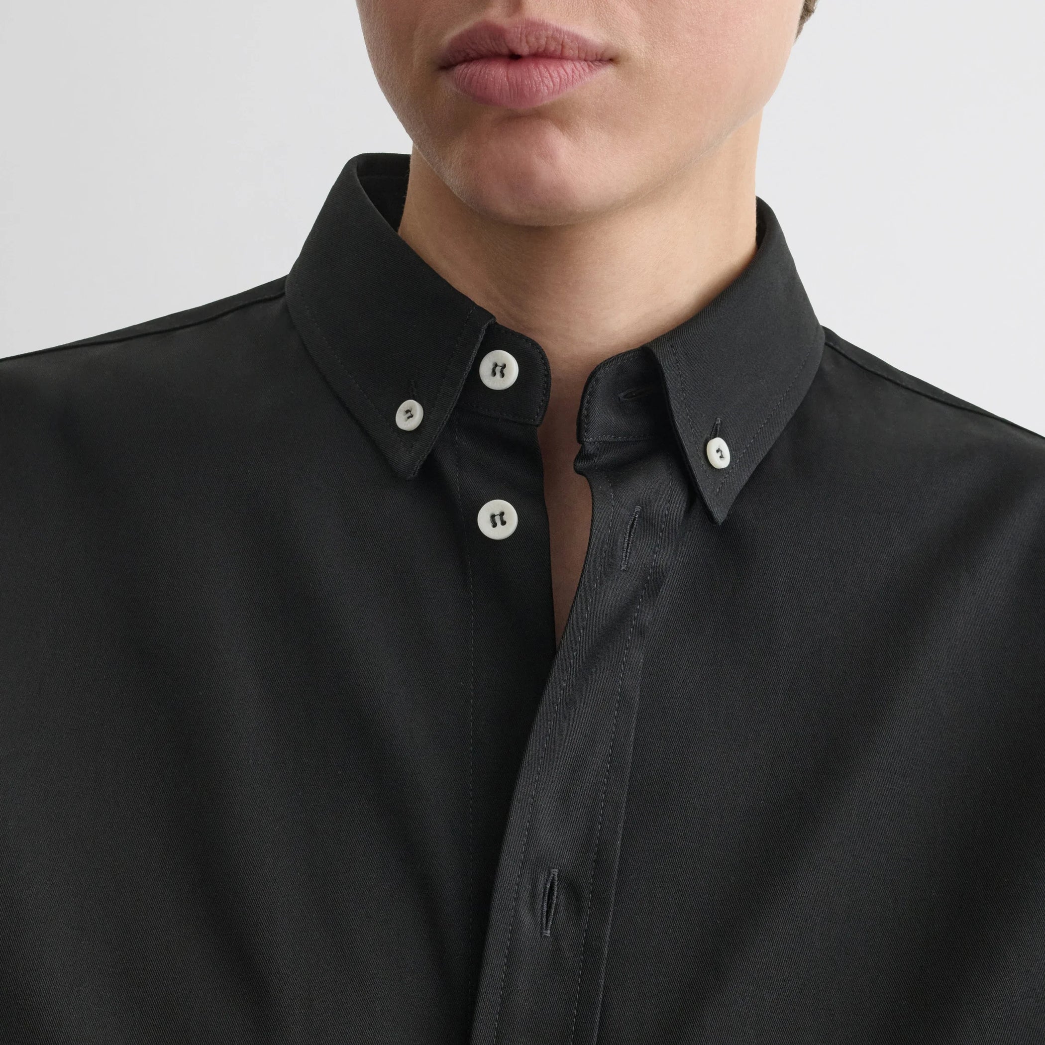 Close up detail view of button collar shirt in black cotton.