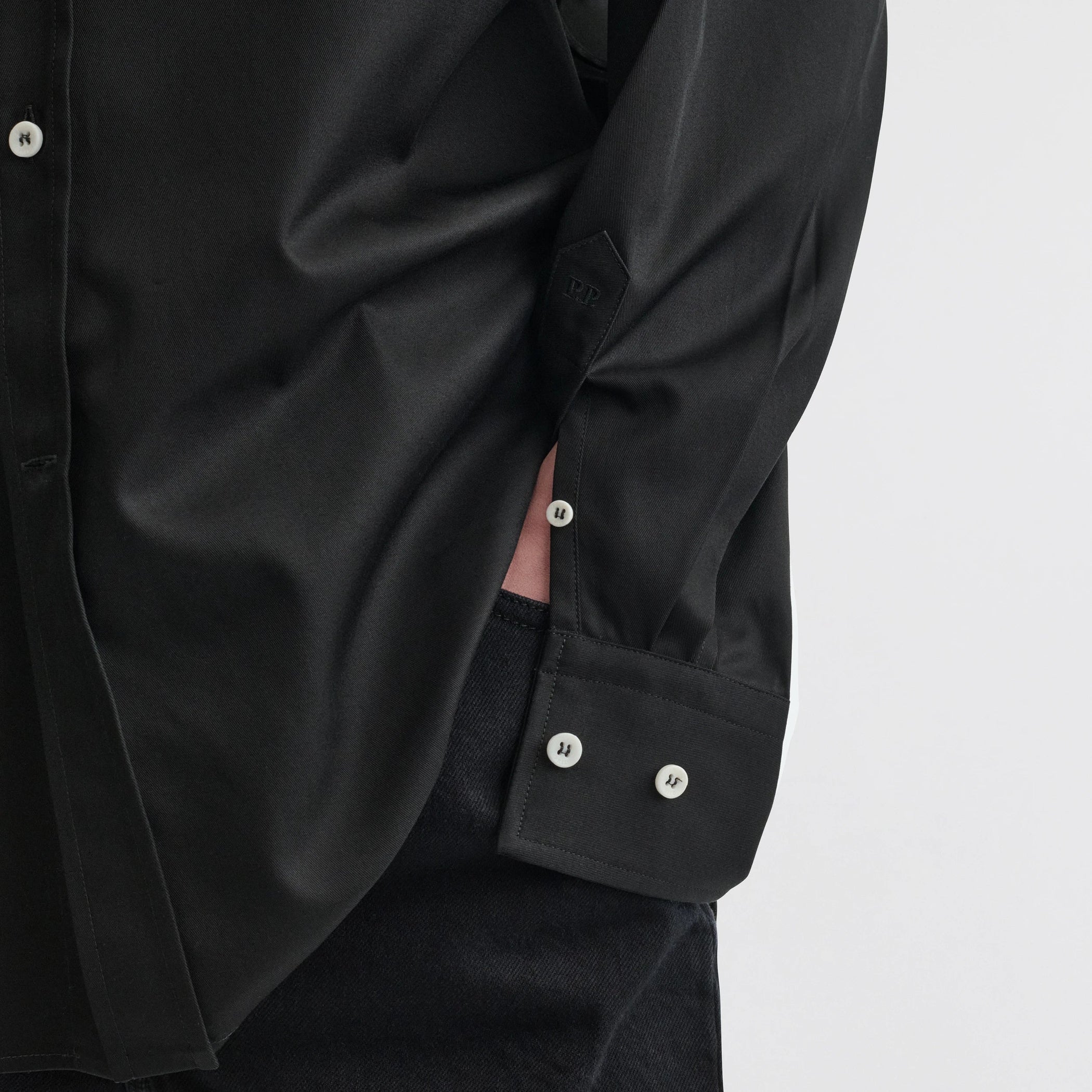 Close up detail view of button collar shirt in black cotton.