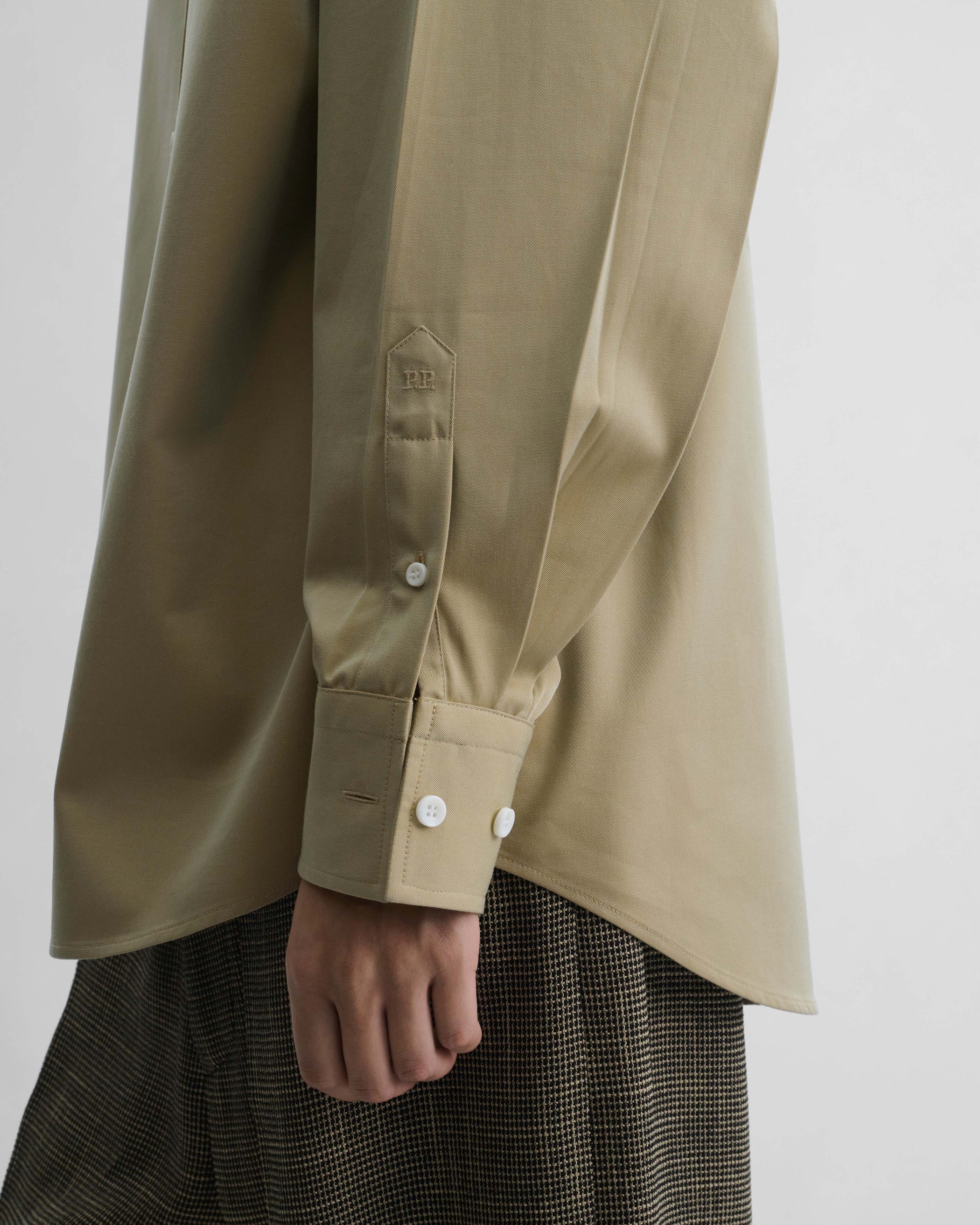 Side detail view of model wearing BUTTON COLLAR SHIRT in trench cotton