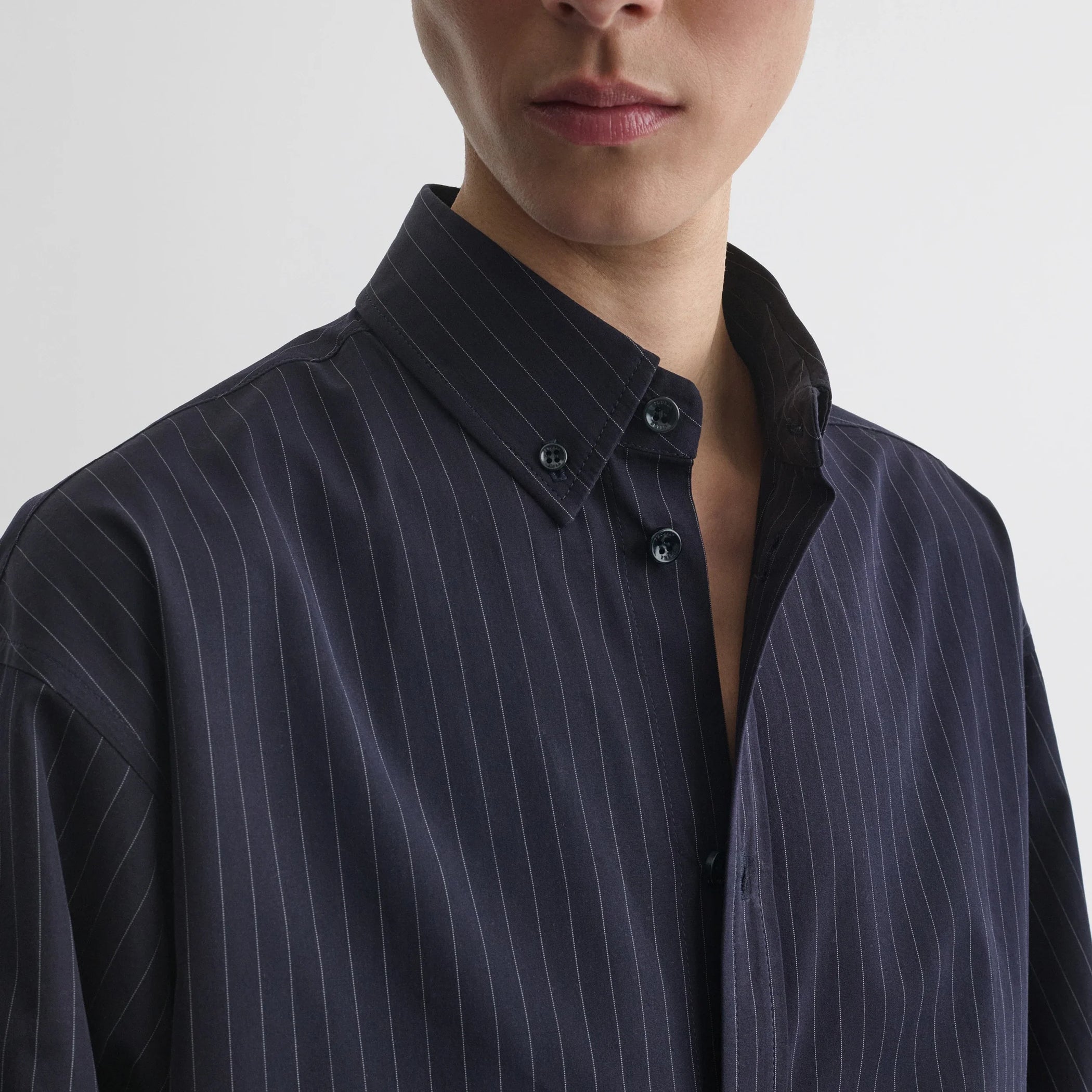 Close up detail view of button collar shirt in midnight pinstripe cotton.
