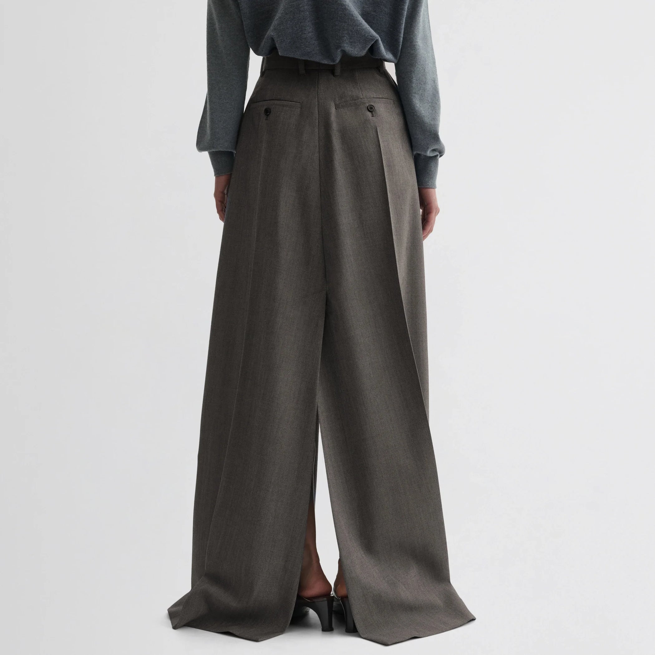 Back view of model wearing double slit tailored skirt in dark taupe wool.