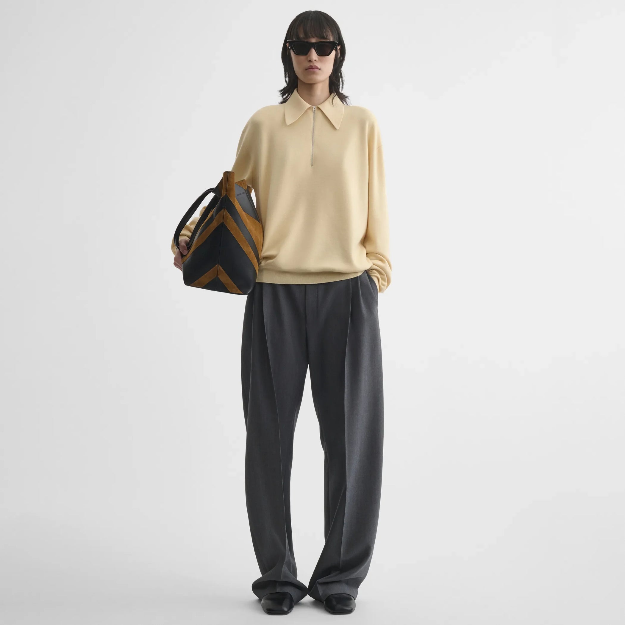 Front view of zip polo in pastel-yellow wool