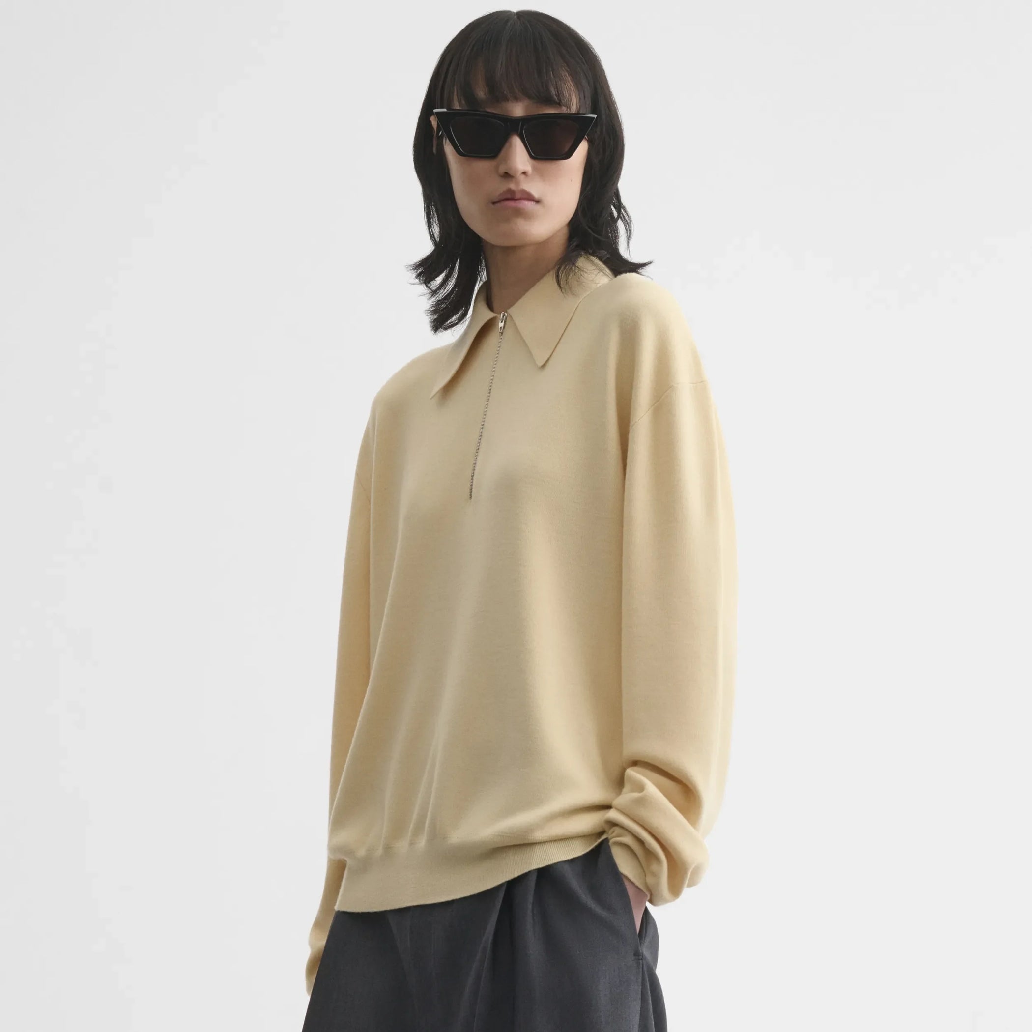 Front view of zip polo in pastel-yellow wool