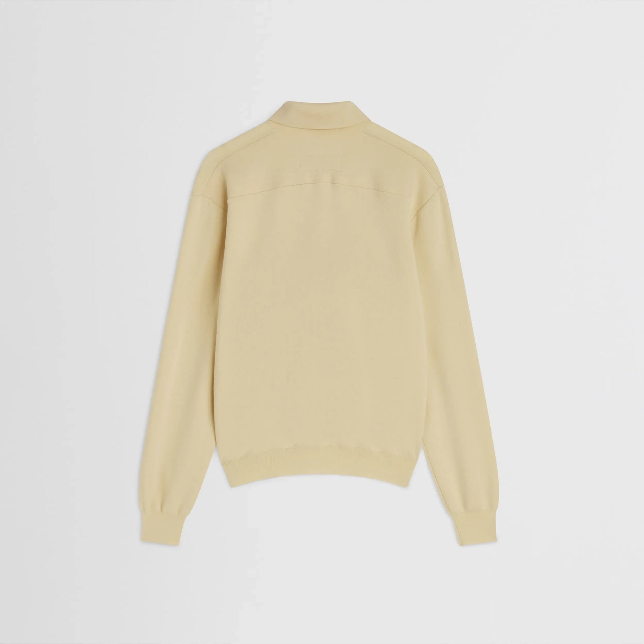 Flat back view of zip polo in pastel-yellow wool
