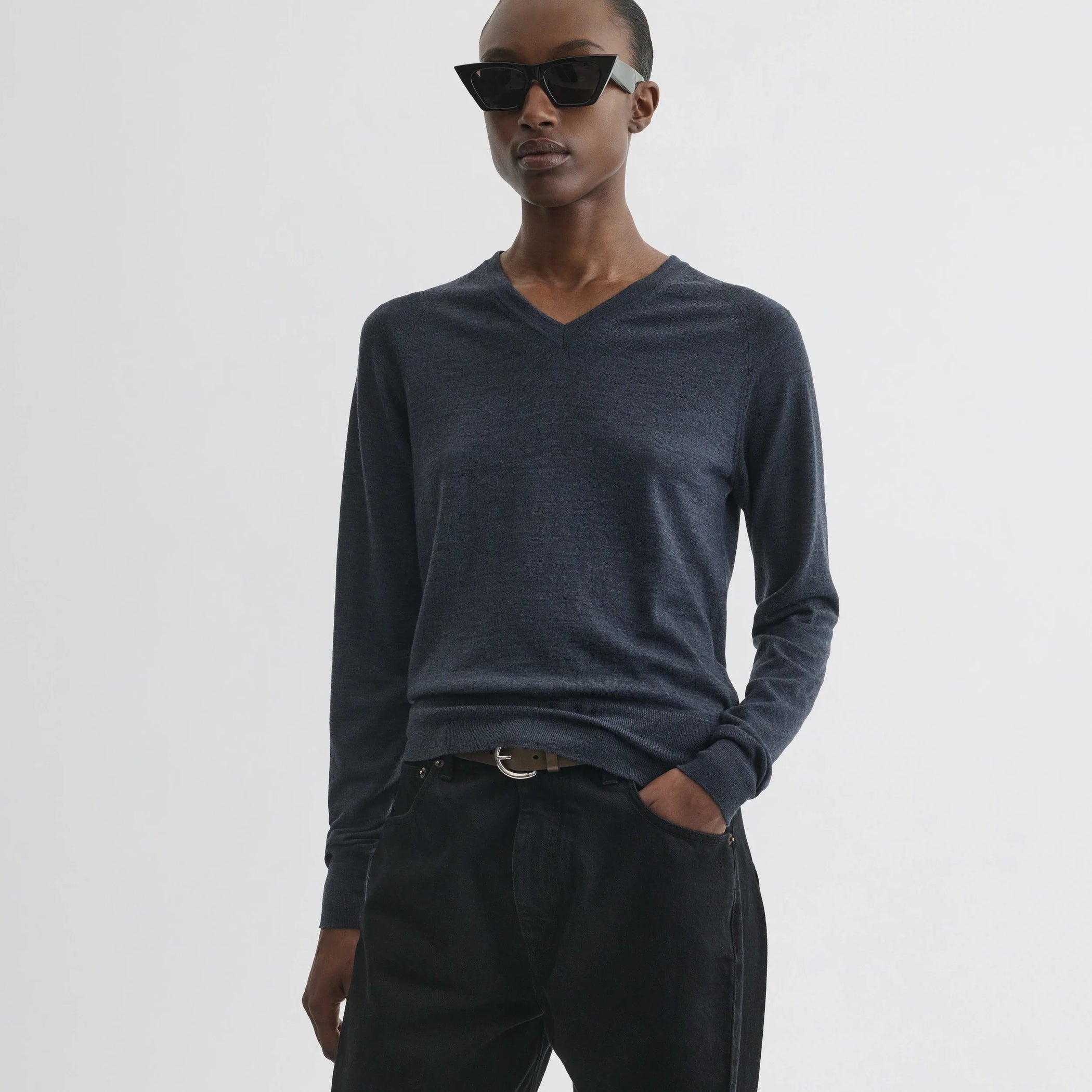 Front view of model wearing shrunk v-neck in dark blue melange wool.
