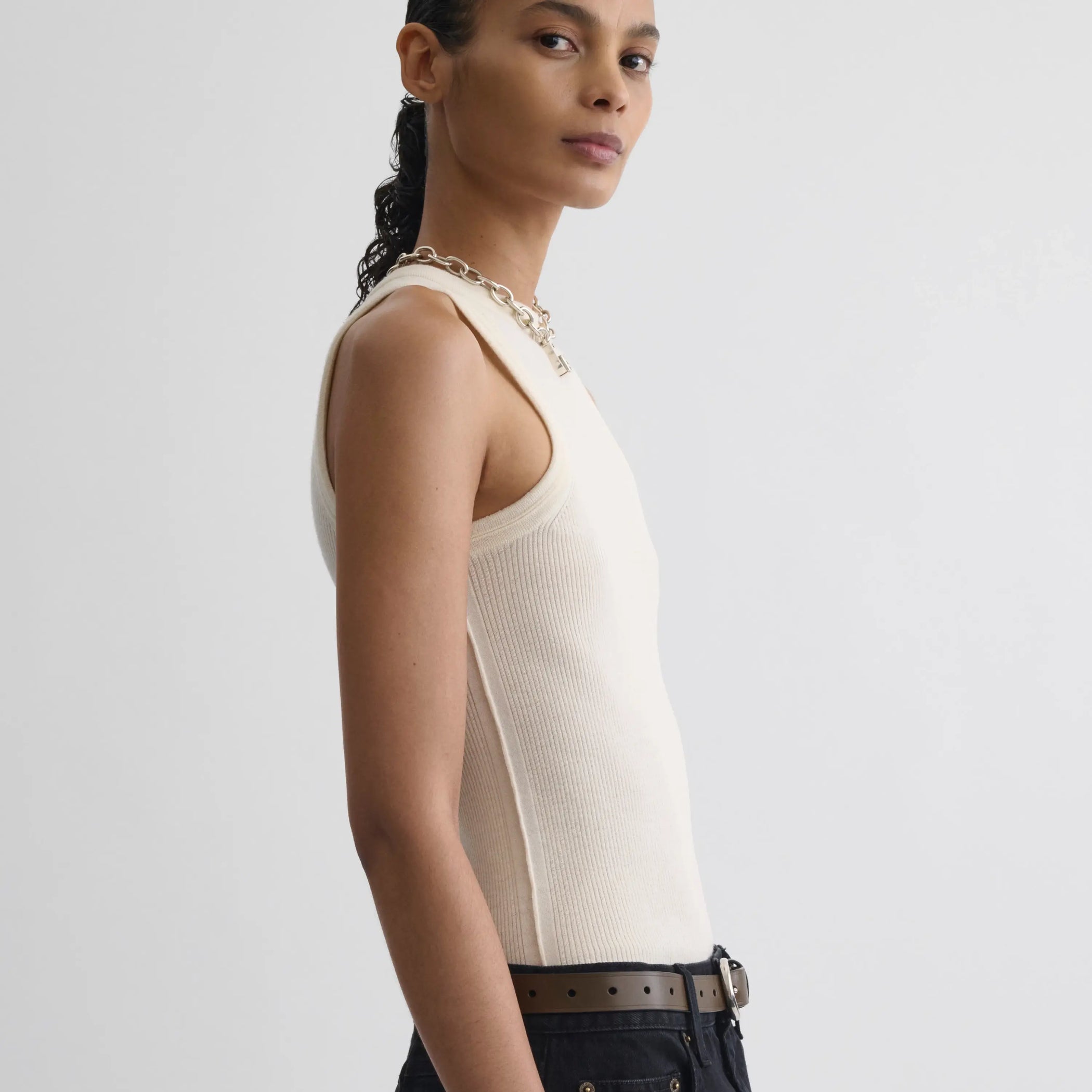 Side view model wearing light merino wool rib tank top in cream