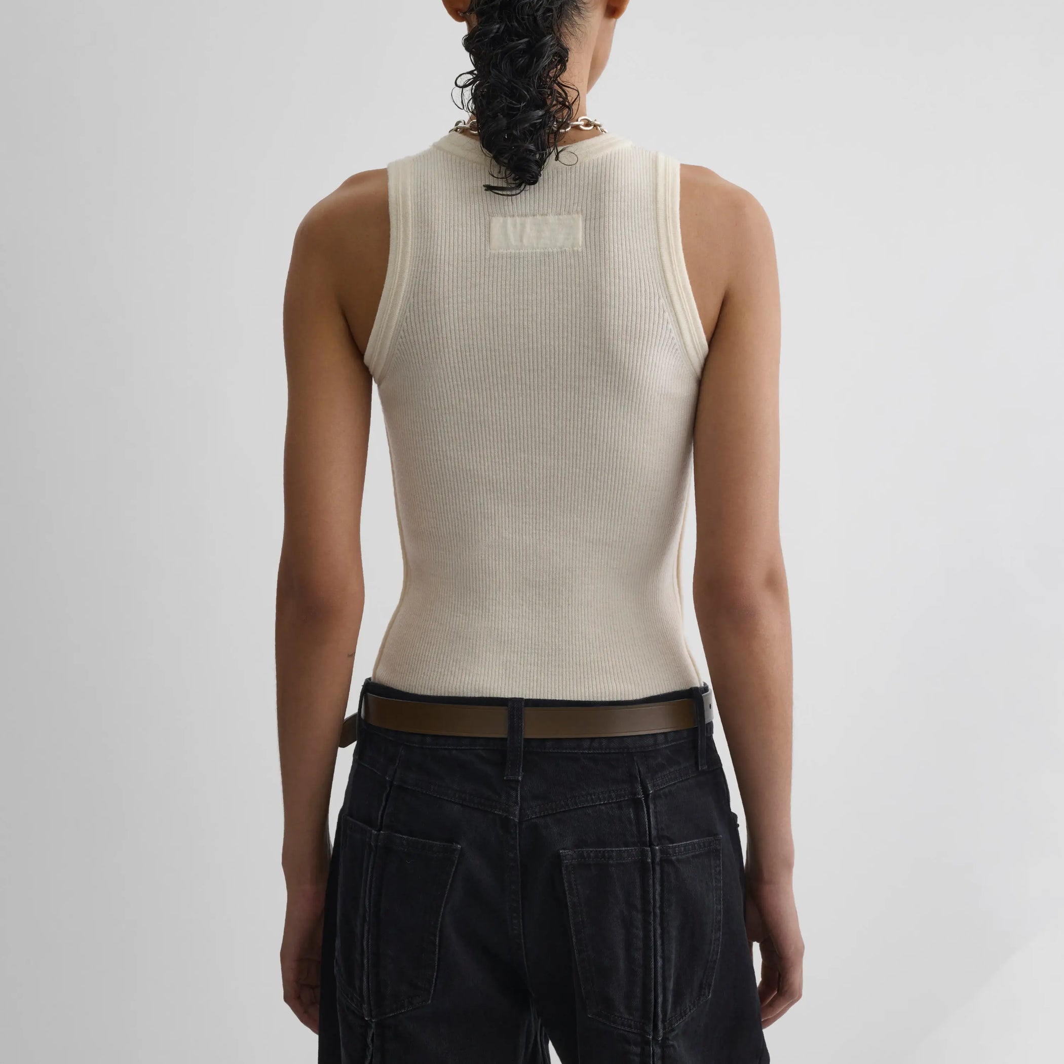 Back view model wearing light merino wool rib tank top in cream