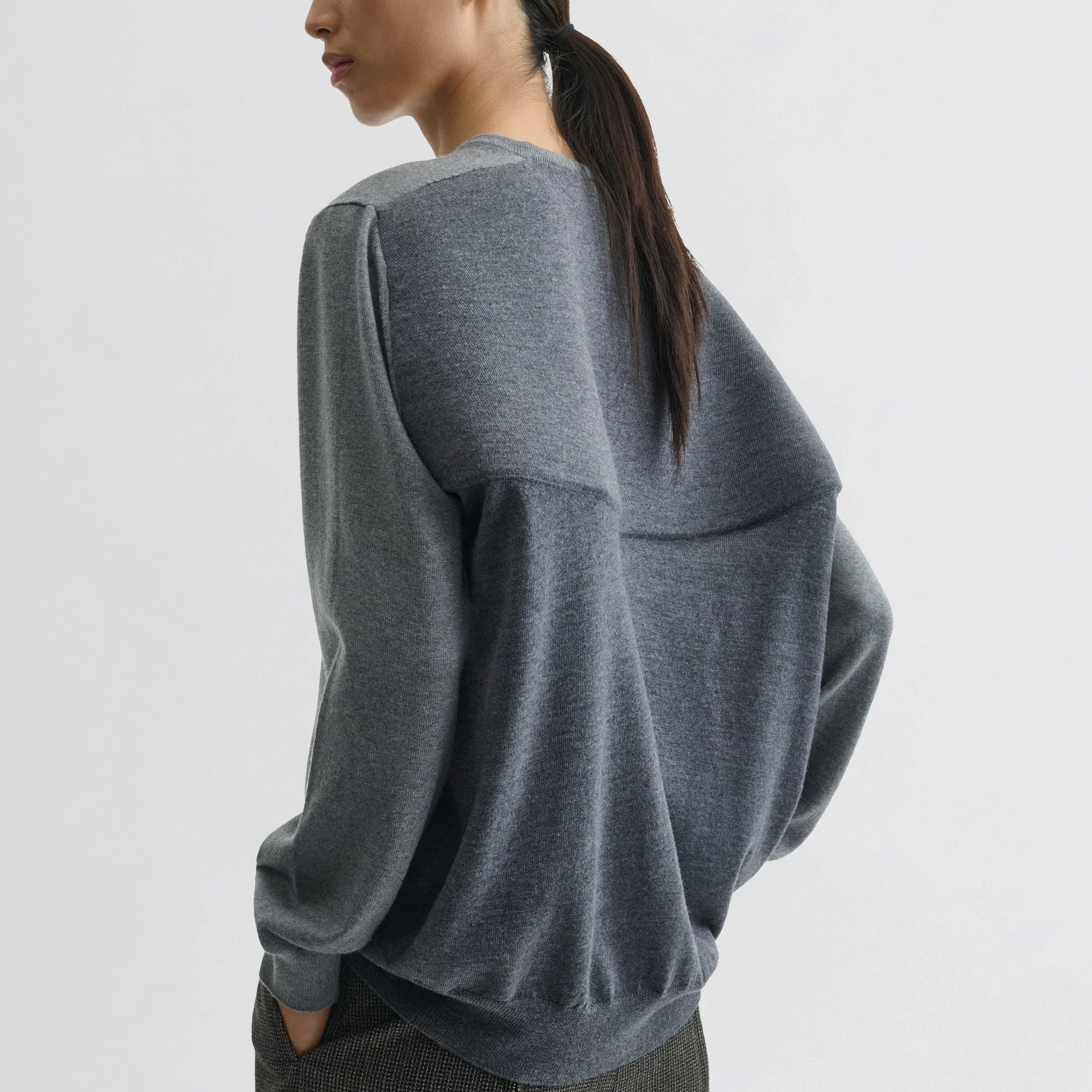 Back view of backed v-neck sweater in light grey wool.