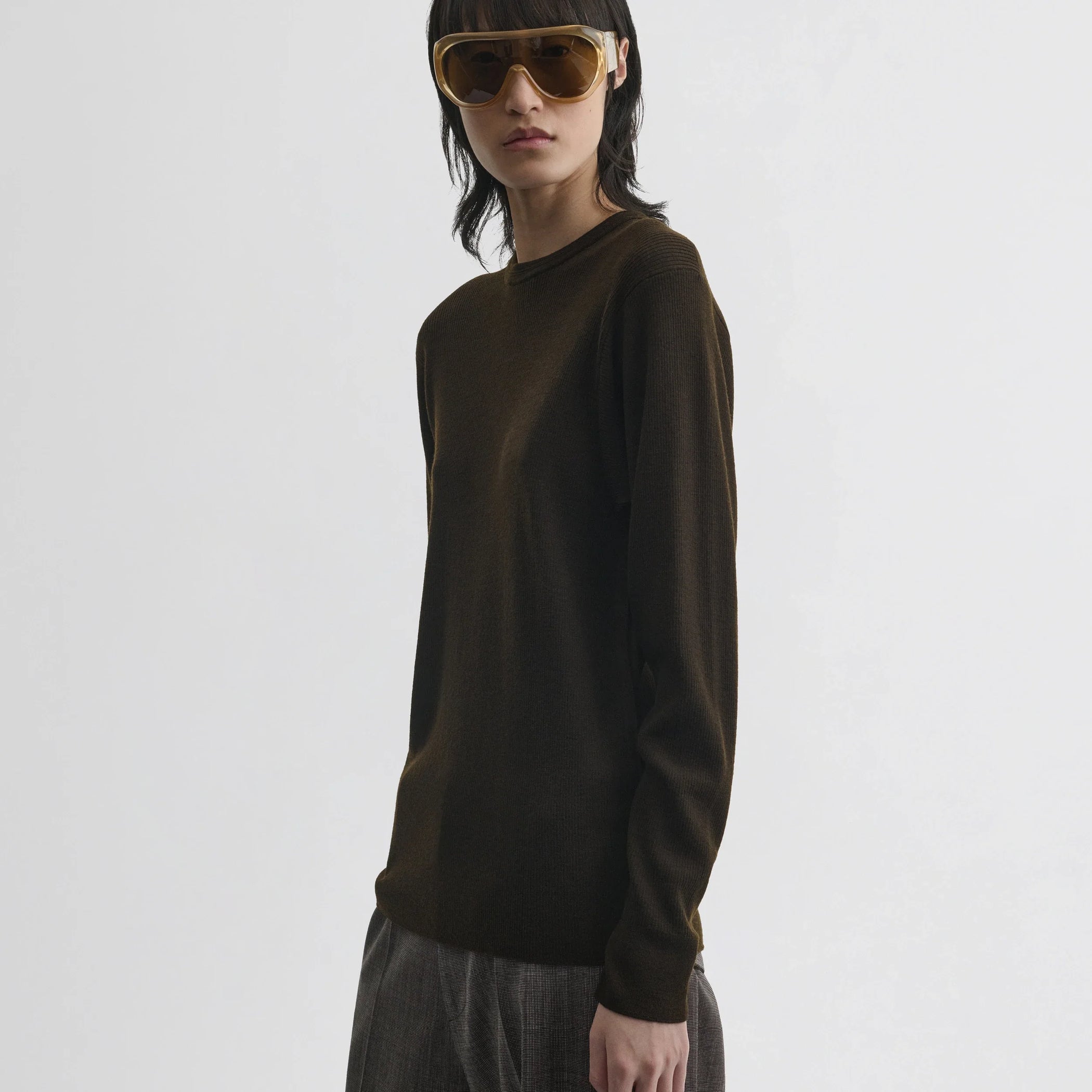Side view of model wearing batwing crewneck in dark khaki wool.