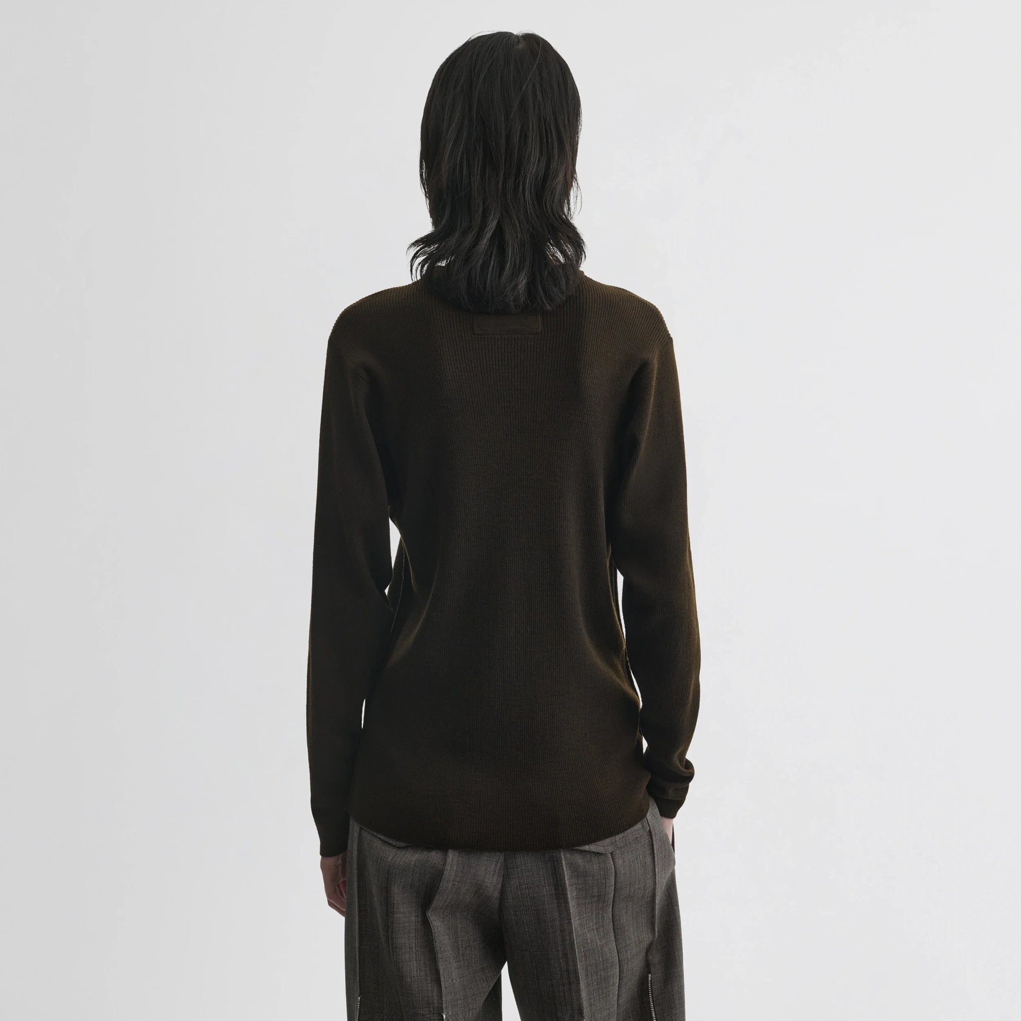 Back view of model wearing batwing crewneck in dark khaki wool.