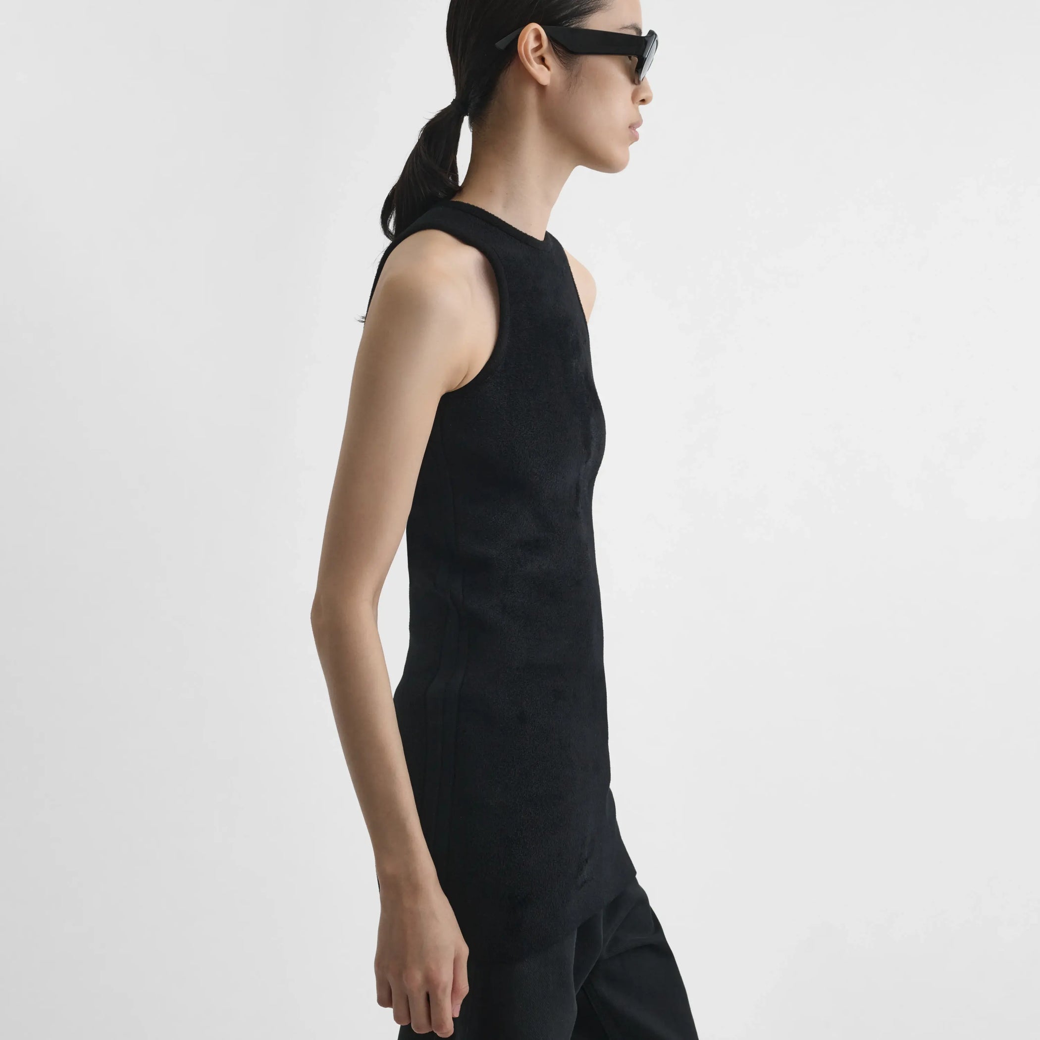 Side view of model wearing Tank Top in black.