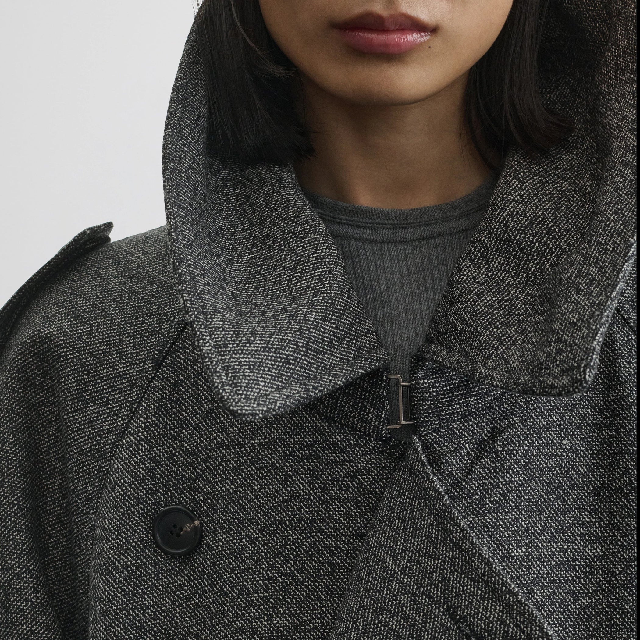 Close up detail view of padded trench coat in salt and pepper wool.