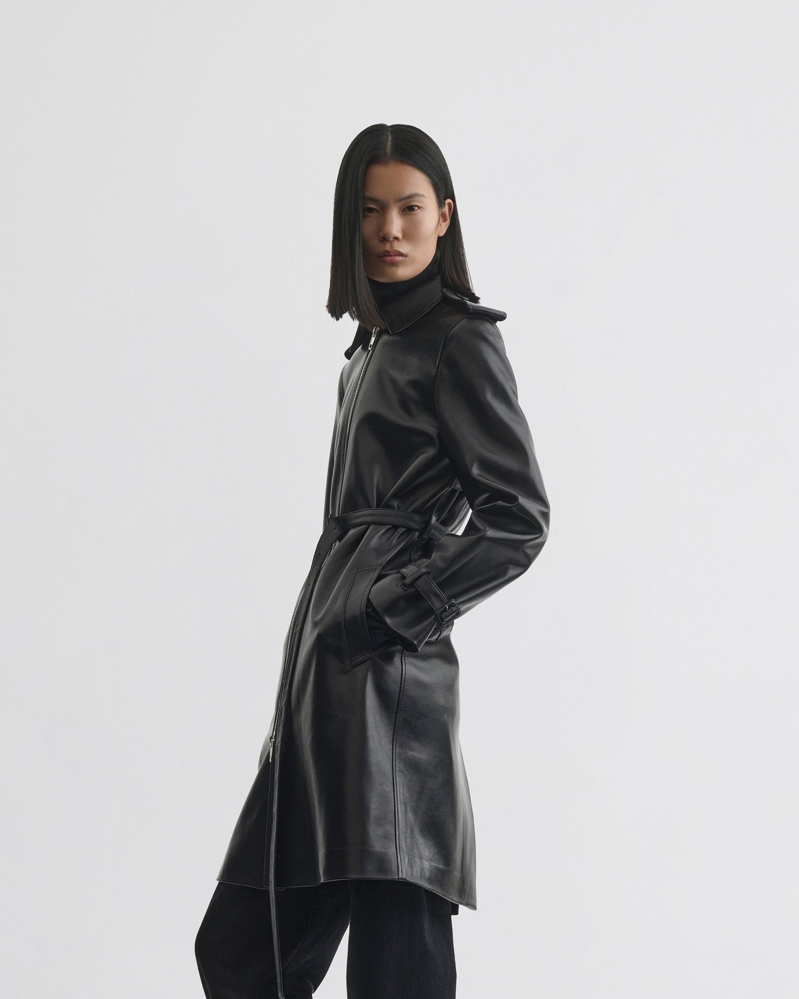 Side view of model wearing Short Trench in black leather