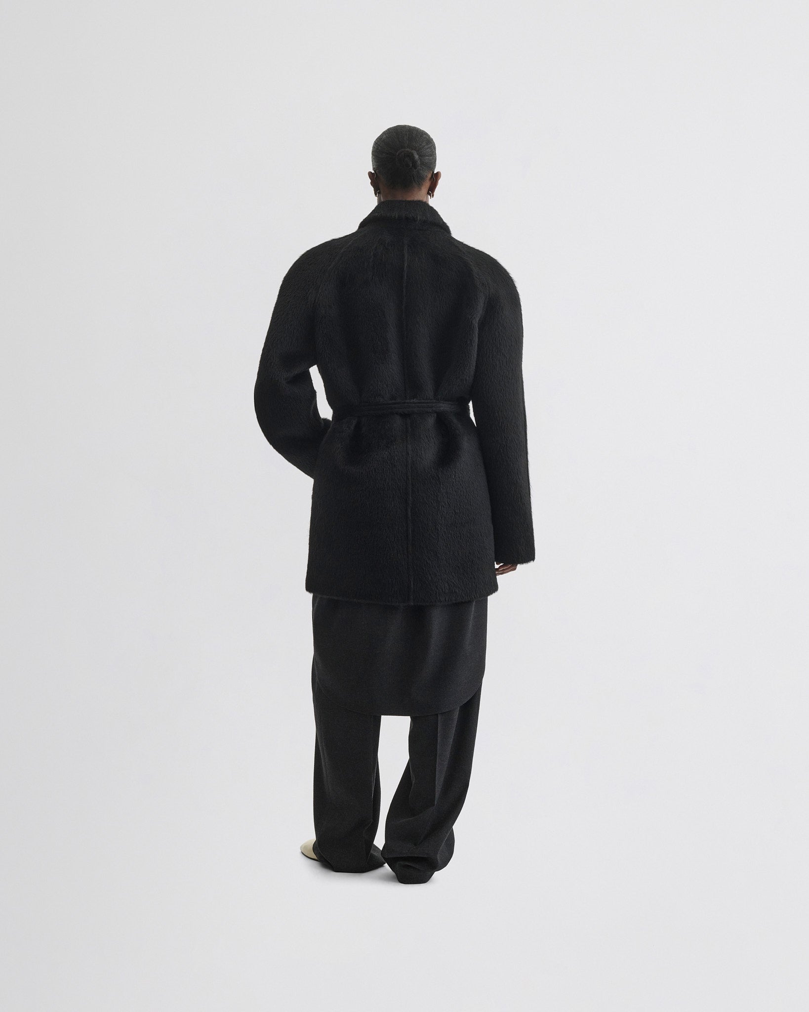 Back view of model wearing Cropped Car Coat in black alpaca wool