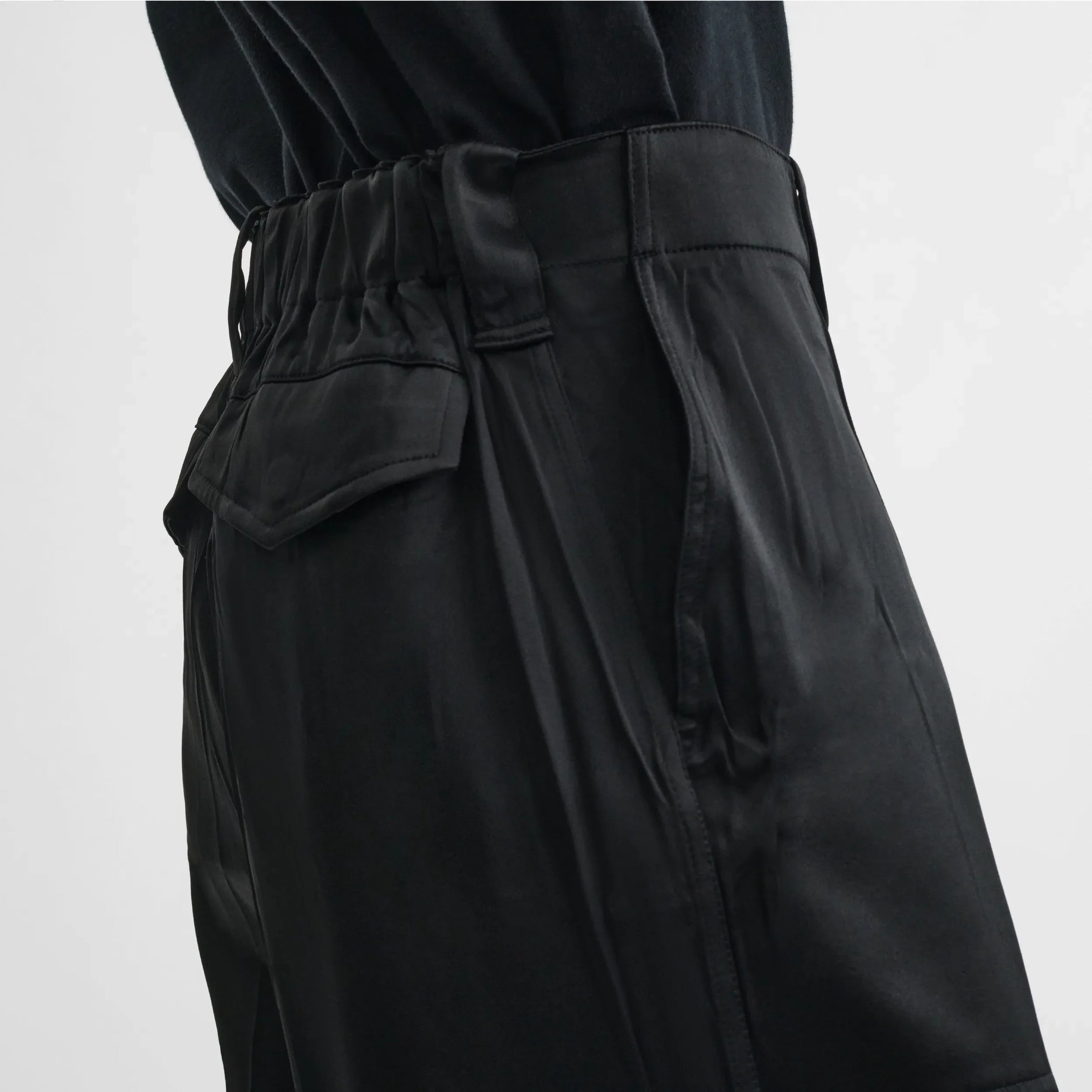 Close up detail view of liquid cargo trousers in black silk