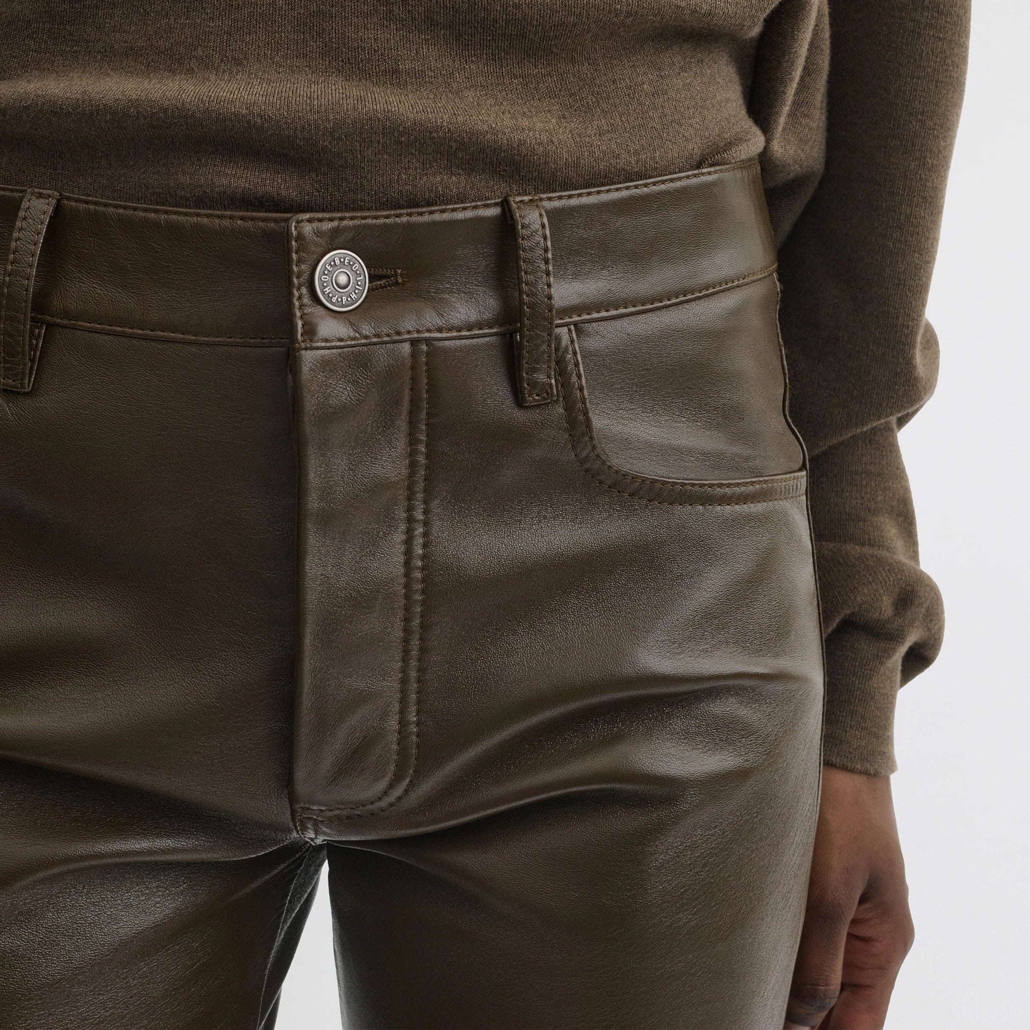 Close up detail view of straight leg jeans in green bronze leather.