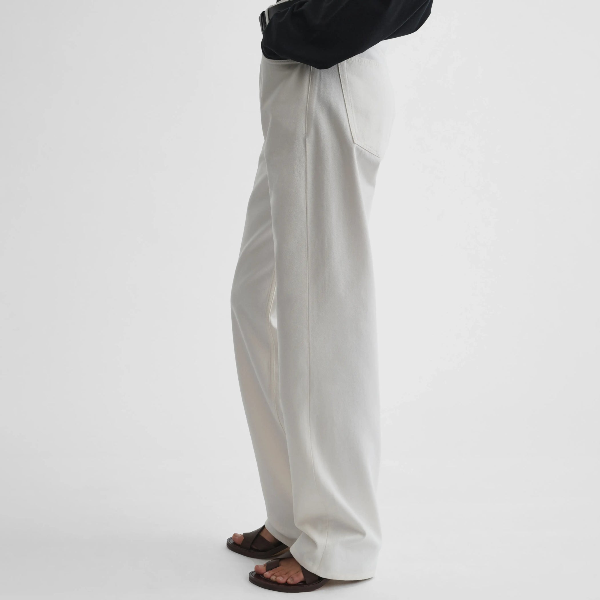 Side view of model wearing Classic Jeans in plaster white.