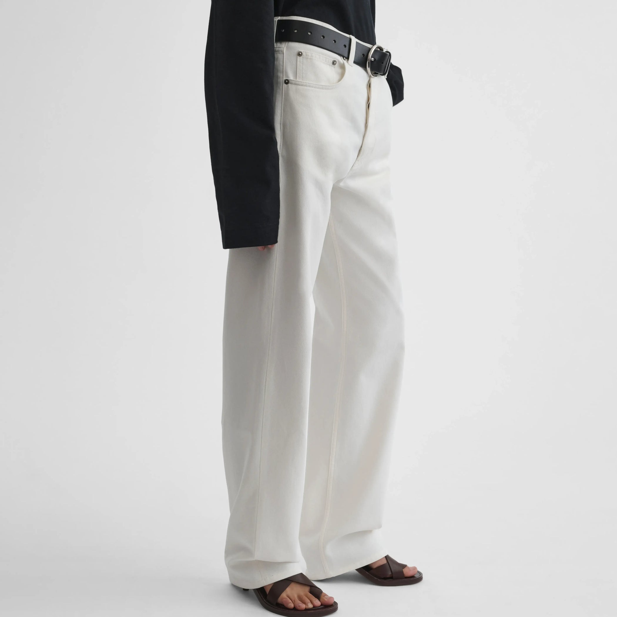 Angled view of model wearing Classic Jeans in plaster white.