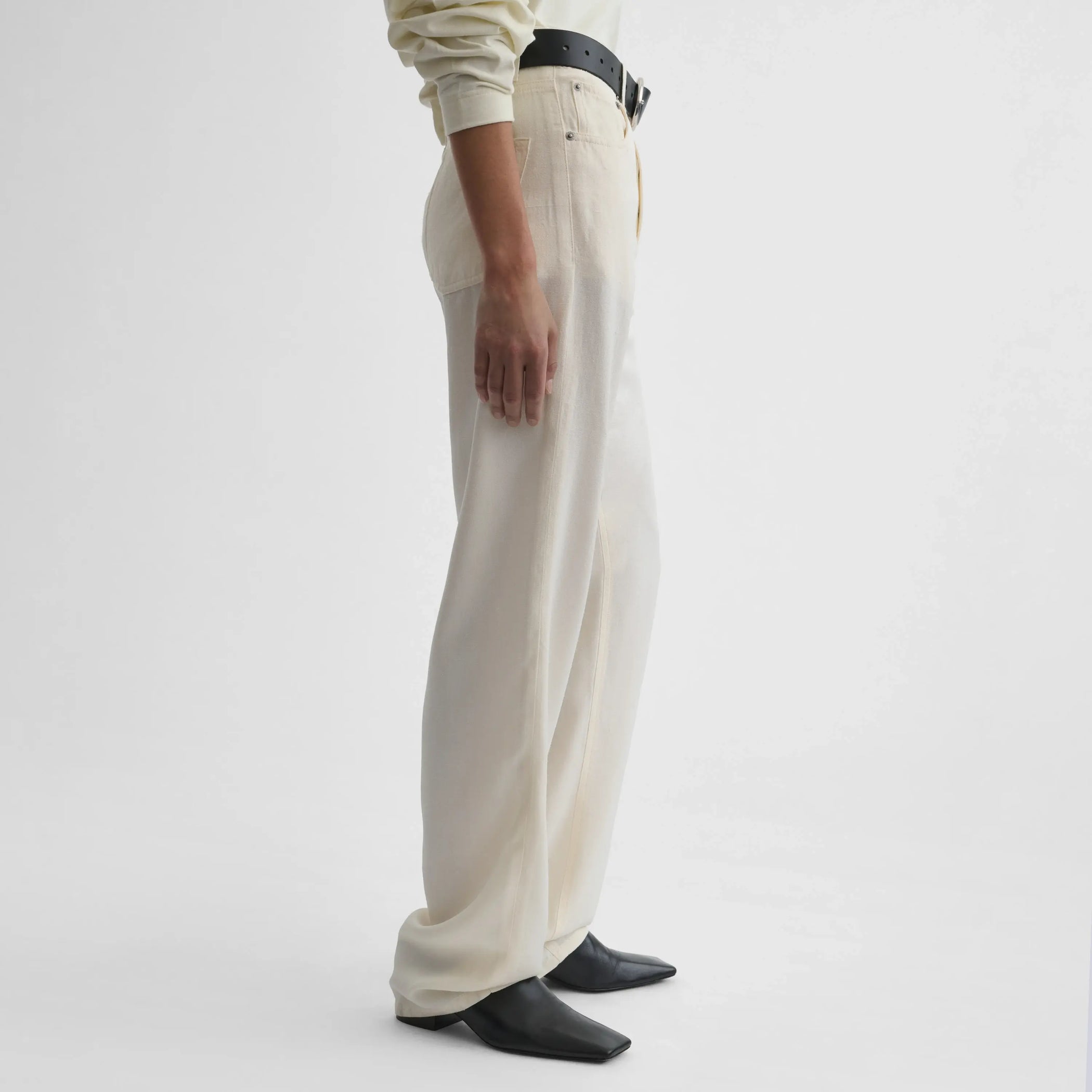 Side view of model wearing Classic Jeans in off white.