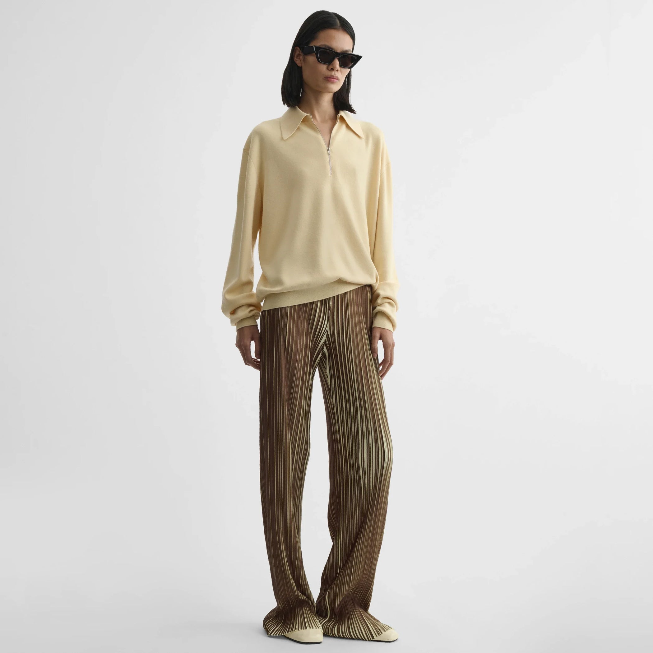 Front view of model wearing razor pleat trousers in khaki polyester.