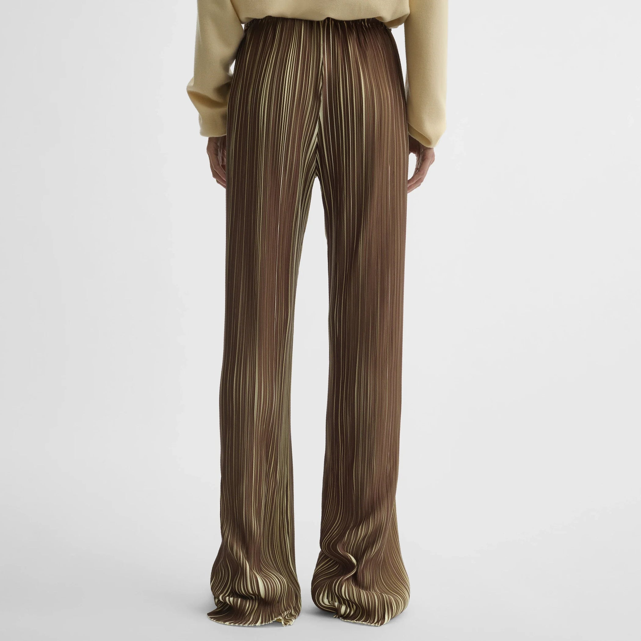 Back view of model wearing razor pleat trousers in khaki polyester.