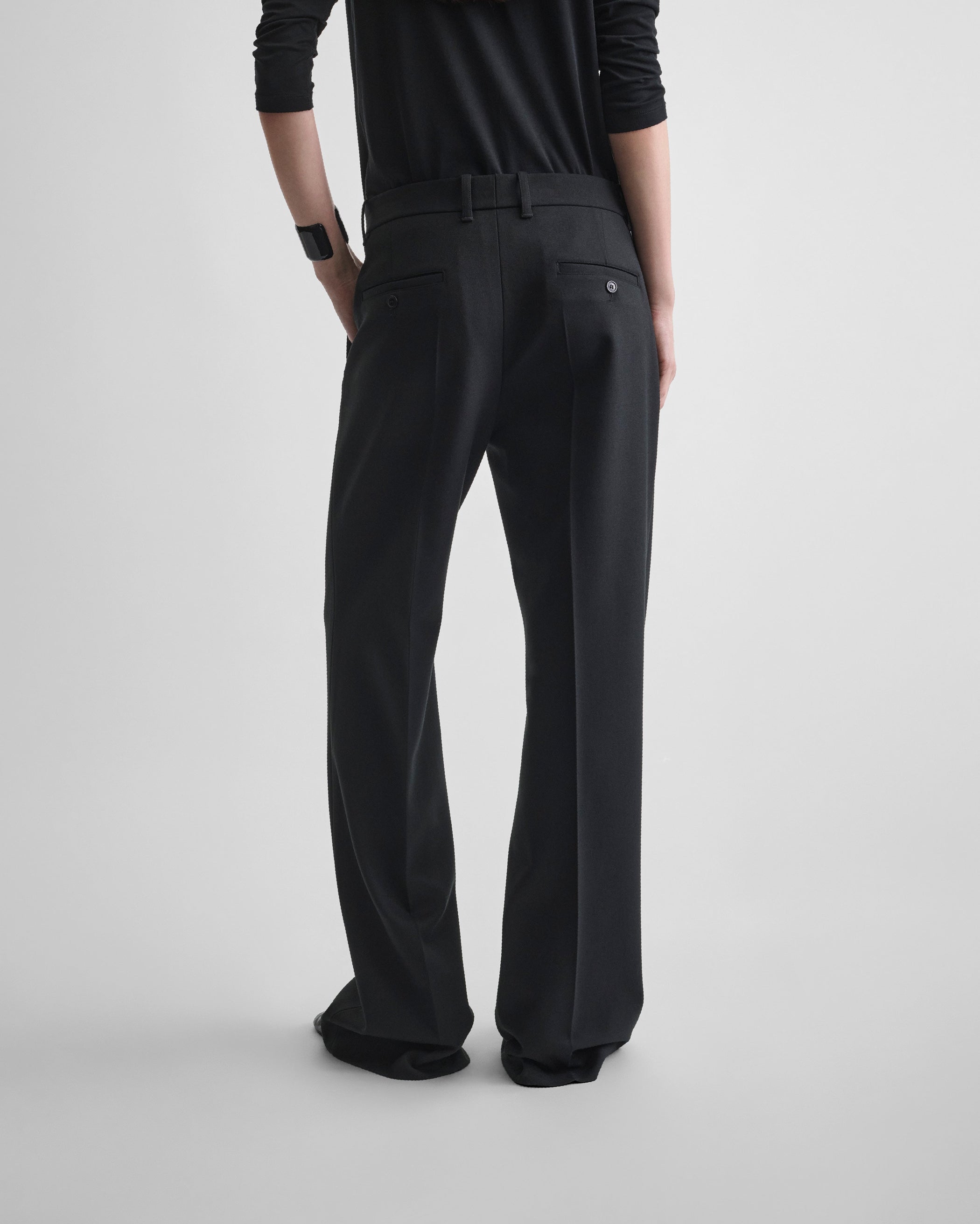 Back view of model wearing BOYISH TAILORED TROUSERS in black wool