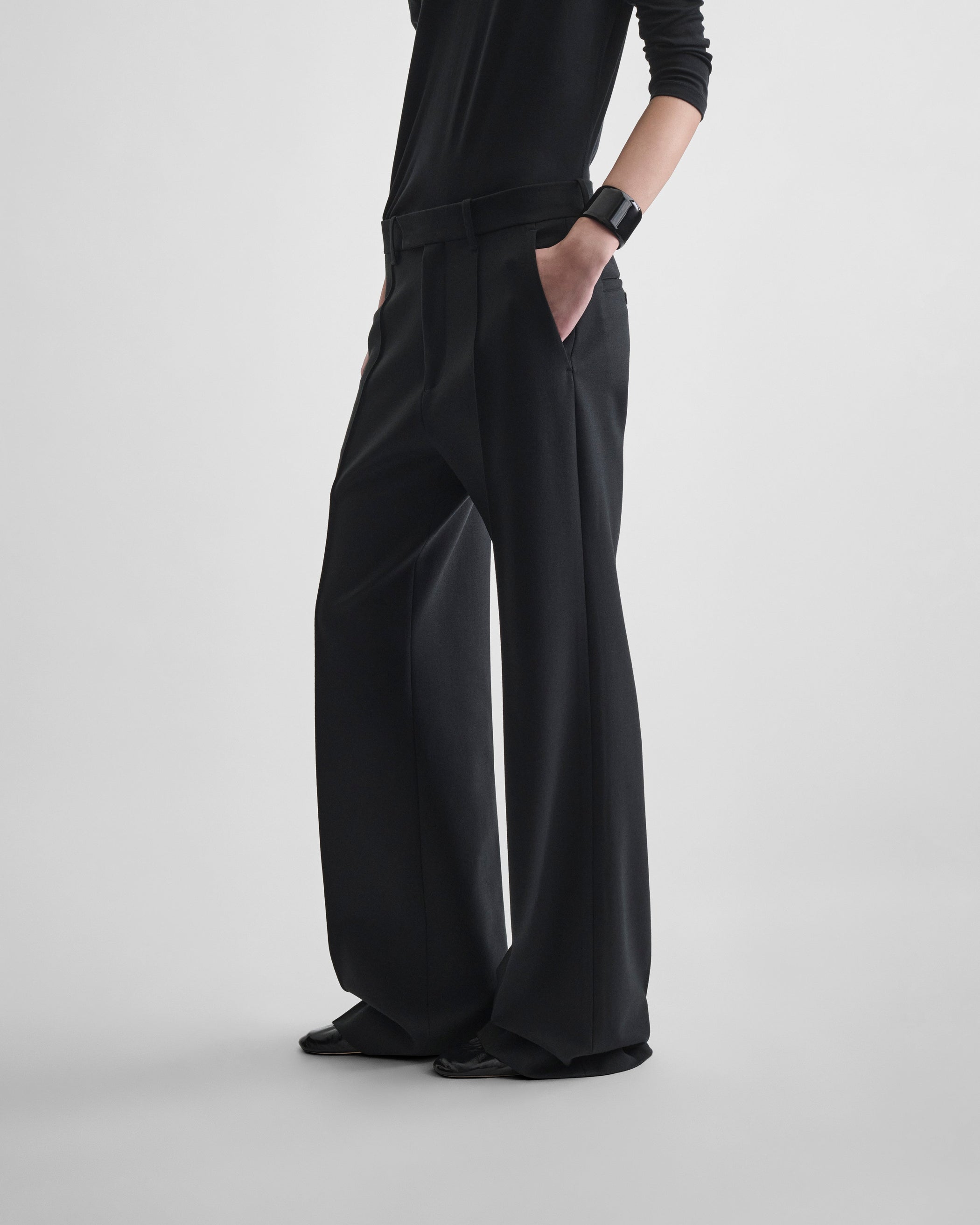 Side view of model wearing BOYISH TAILORED TROUSERS in black wool