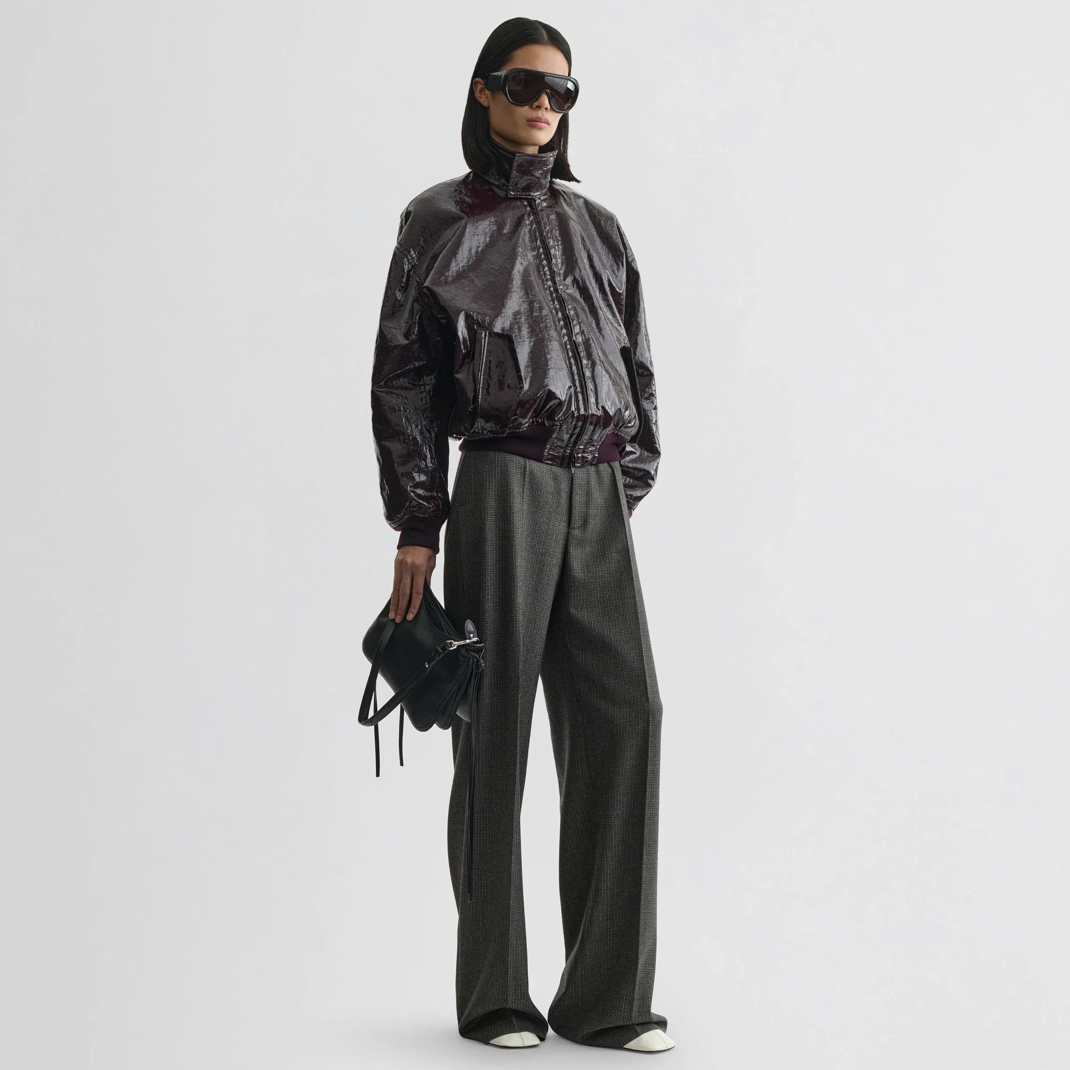 Front view of model wearing zip trousers in green bronze wool.