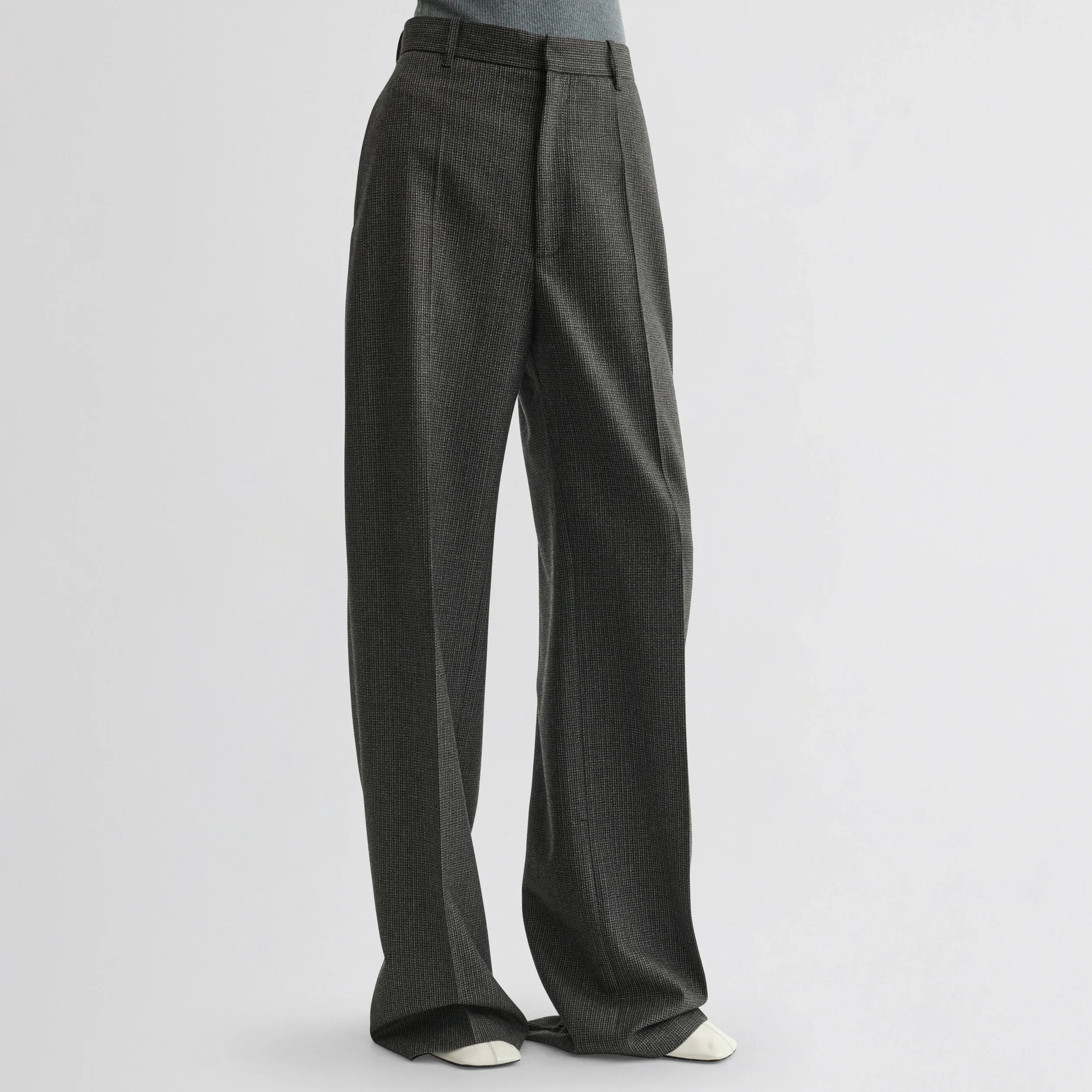 Front view of model wearing zip trousers in green bronze wool.