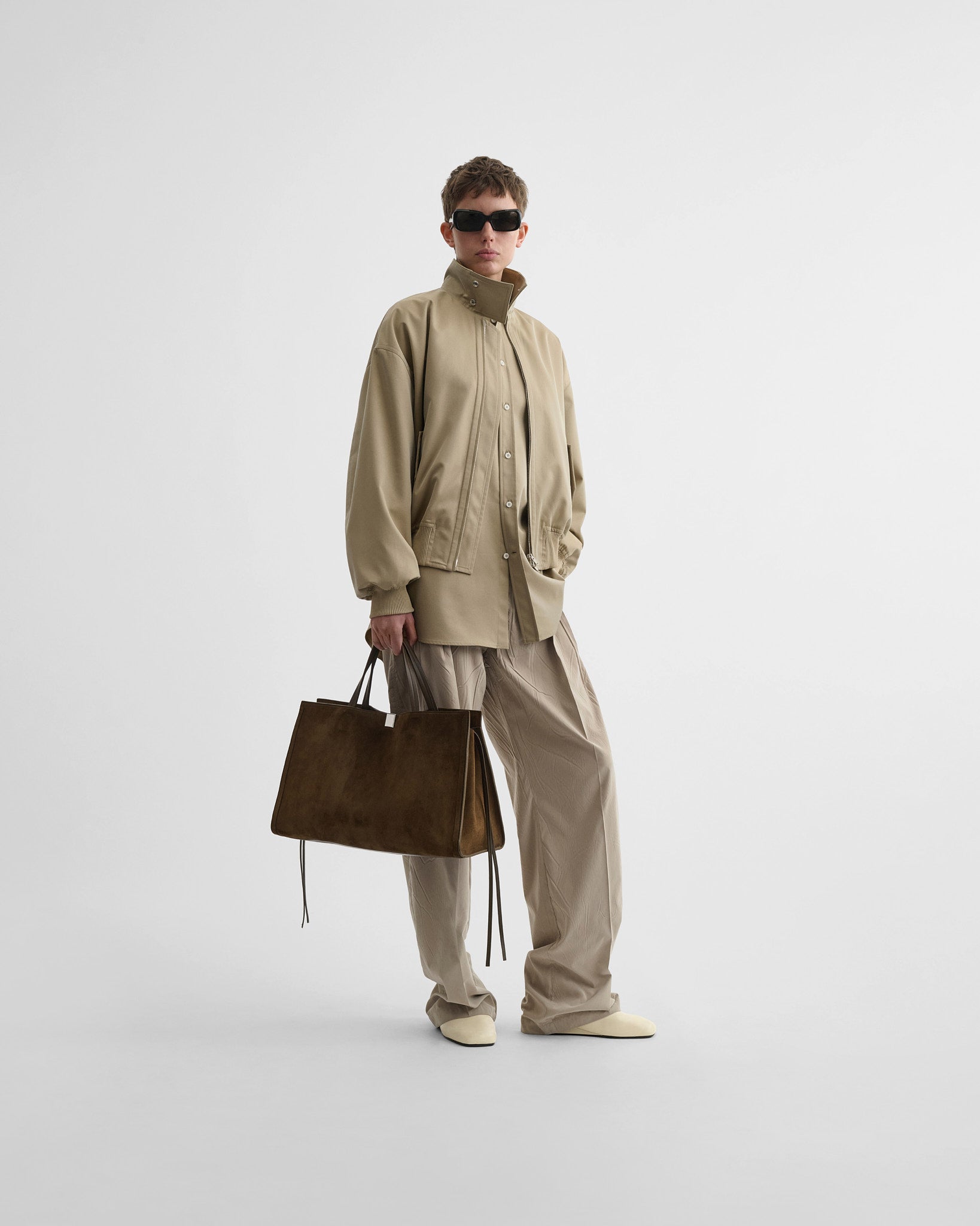 Front view of model wearing golf jacket in trench cotton