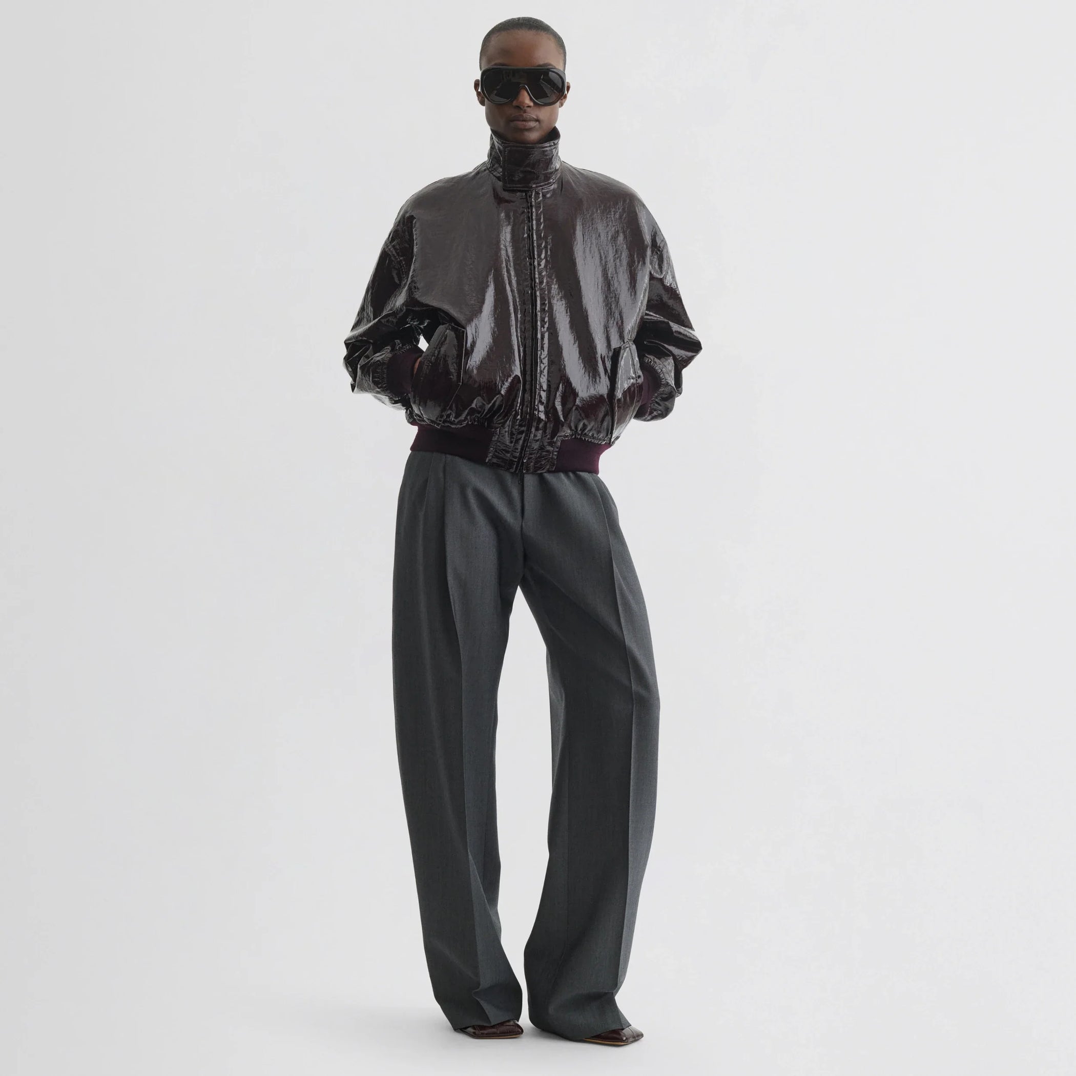 Front view of model wearing golf jacket in burgundy linen canvas.