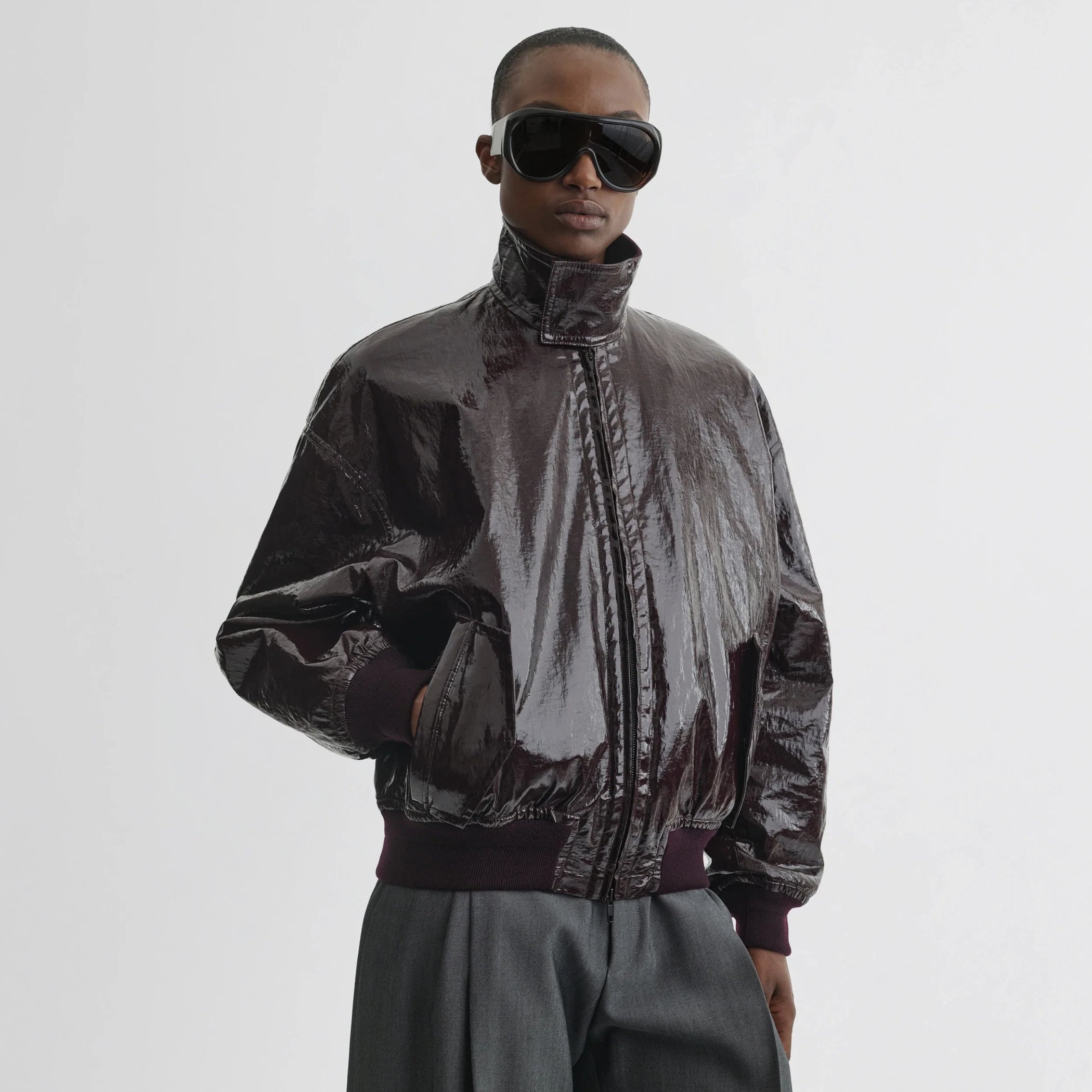 Front view of model wearing golf jacket in burgundy linen canvas.