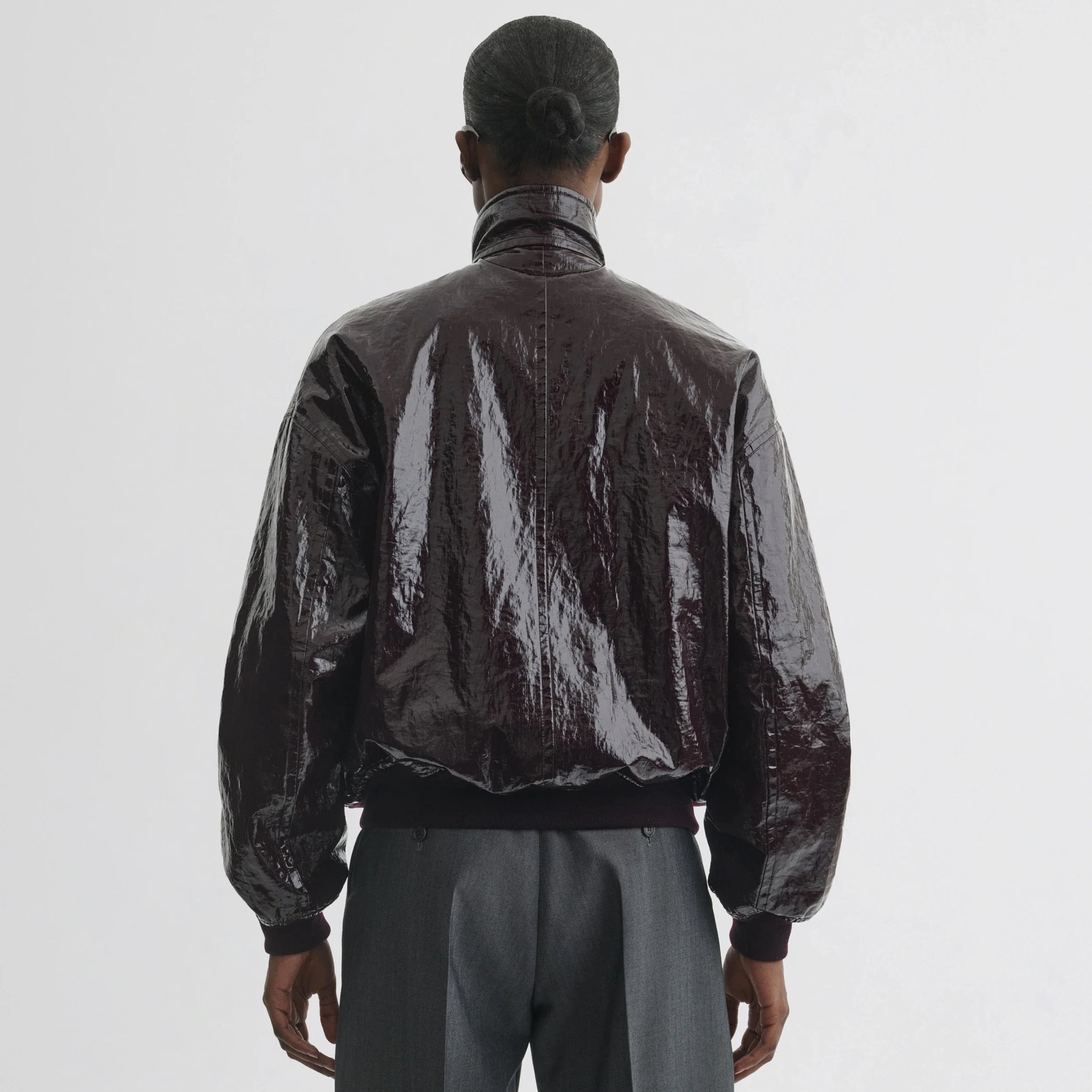 Back view of model wearing golf jacket in burgundy linen canvas.