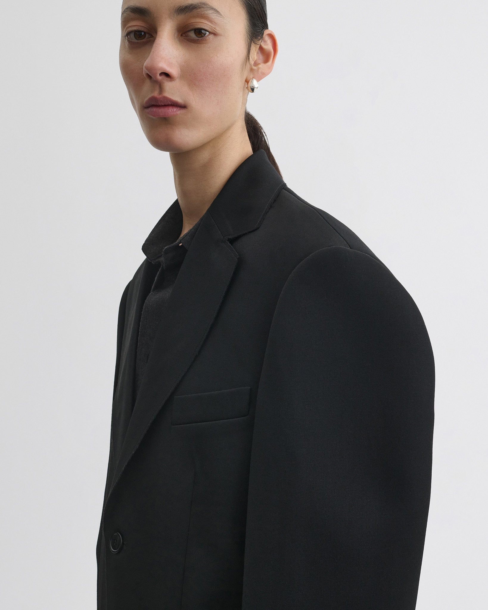 Close up detail view of tuxedo jacket in black wool.