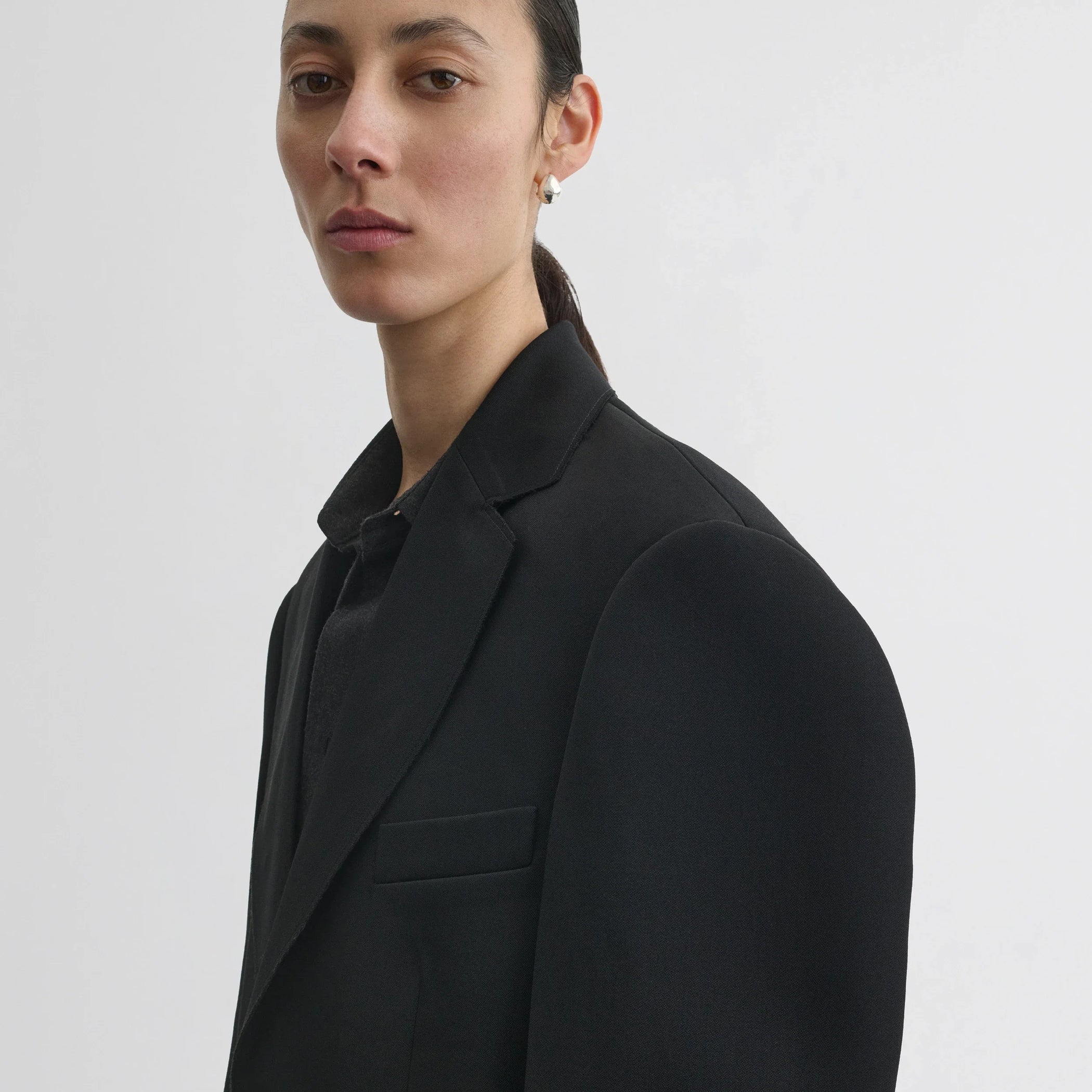 Close up detail view of tuxedo jacket in black wool.