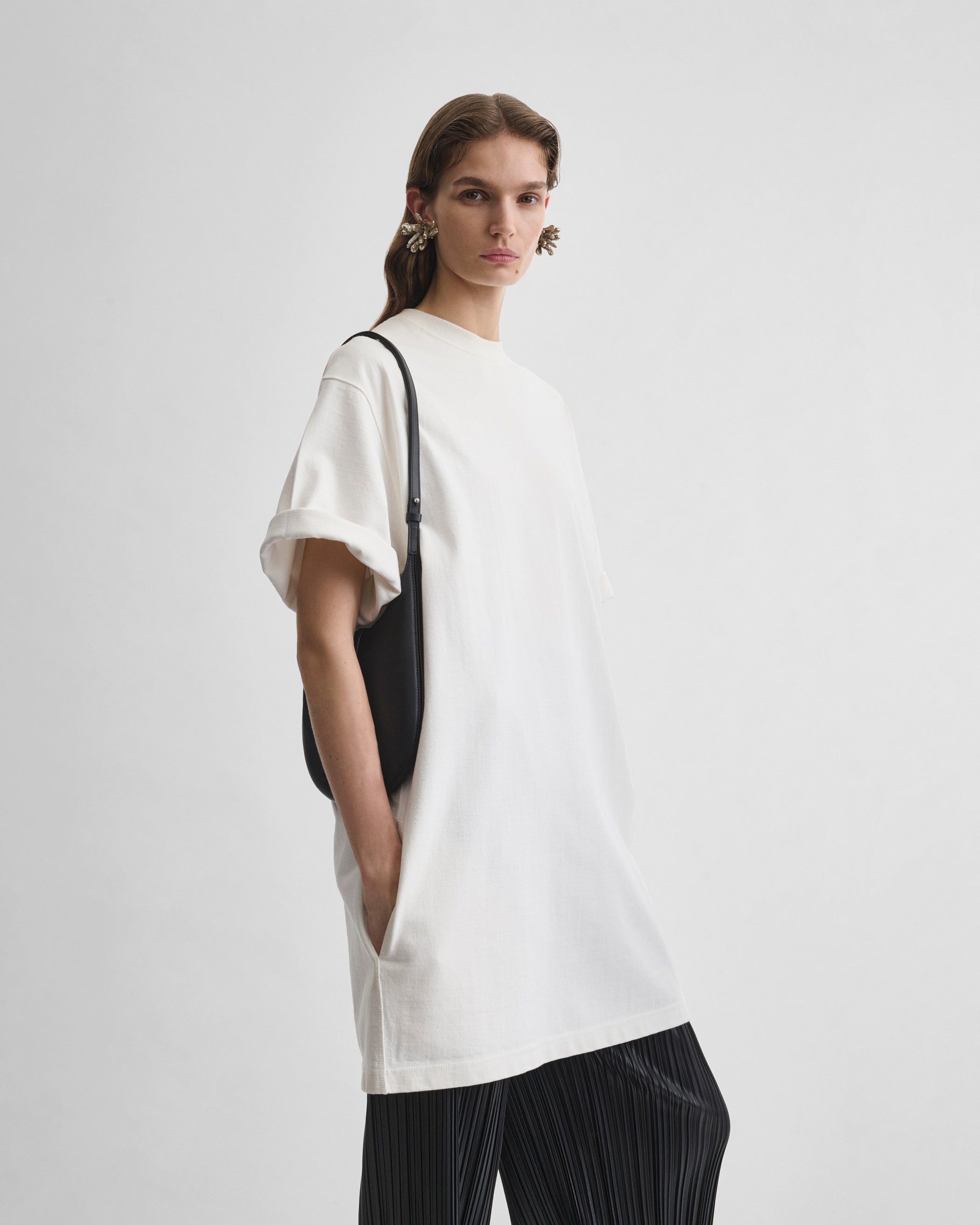 Model wearing MINI BEAN SLING in black leather