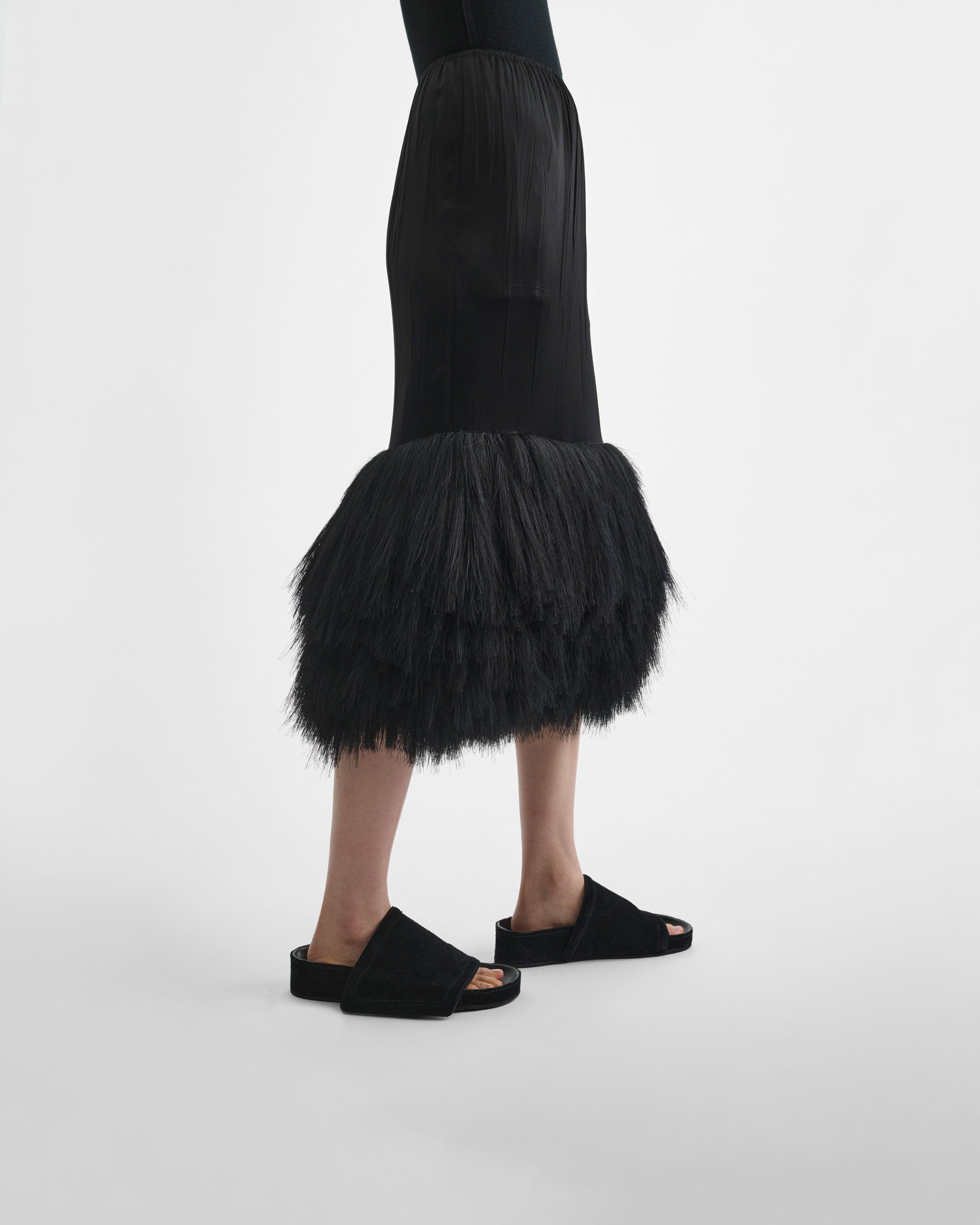 Side view of model wearing FRINGED SLIP SKIRT in black silk