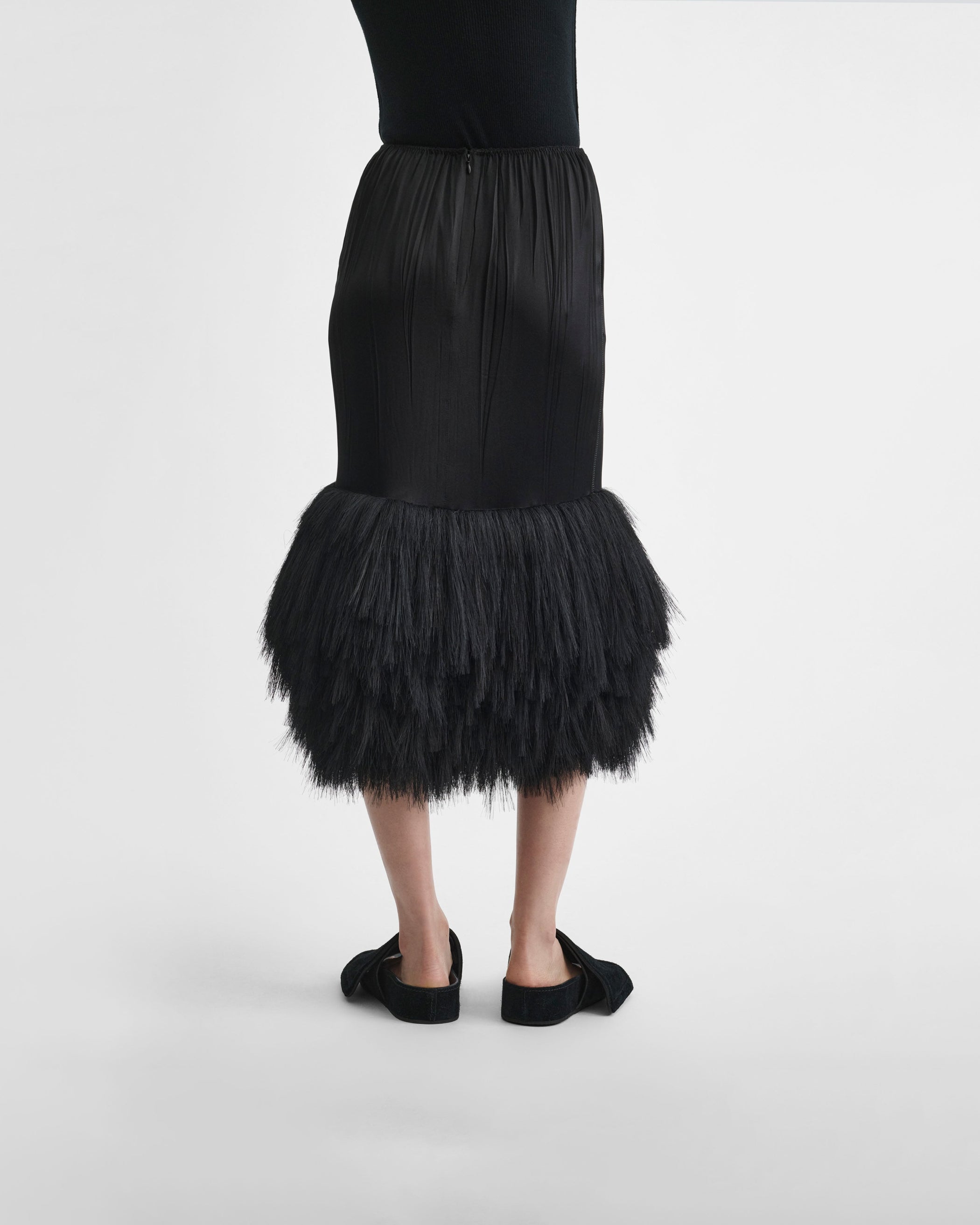 Back view of model wearing FRINGED SLIP SKIRT in black silk