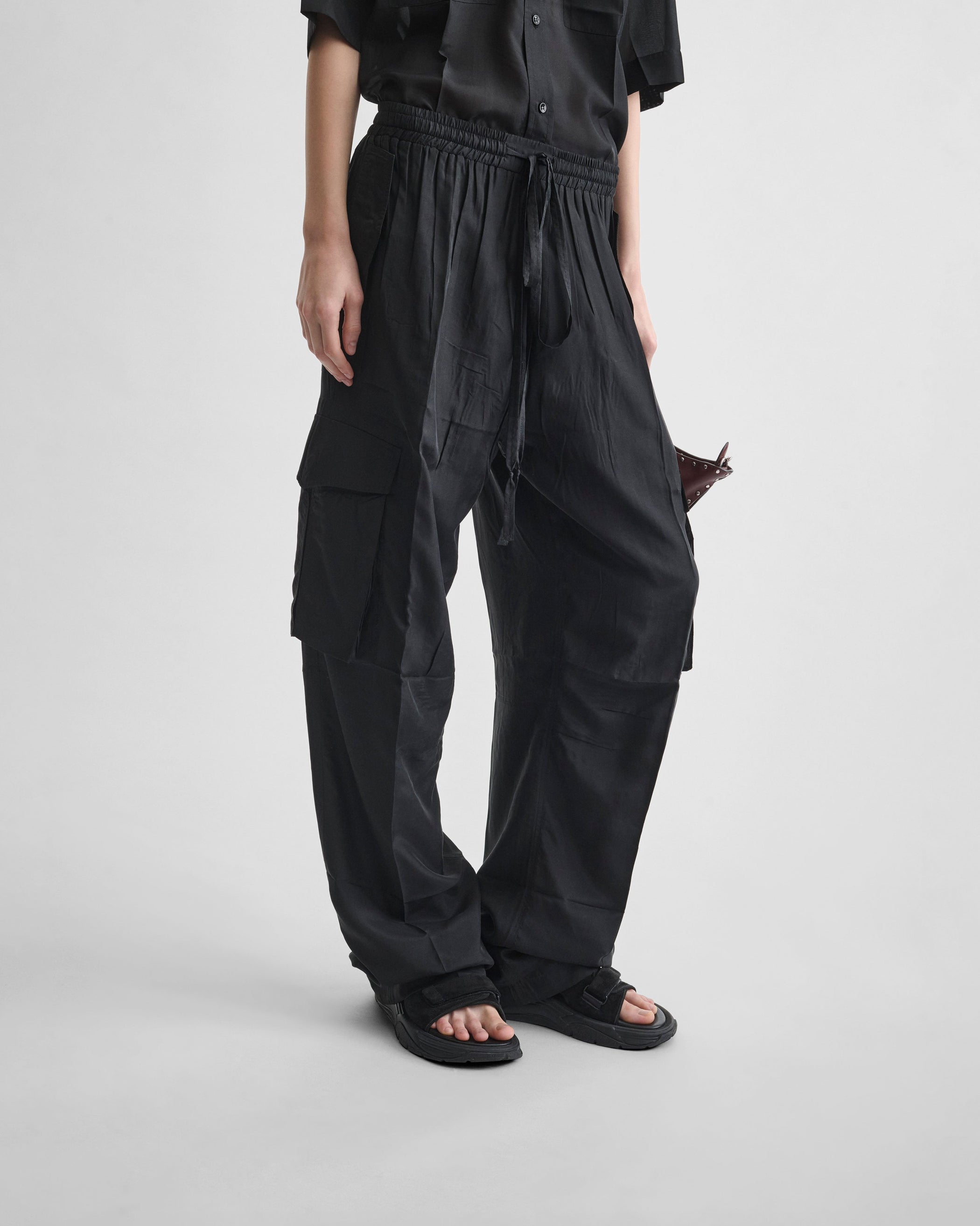 Front detail view of model wearing CARGO TROUSERS in black silk