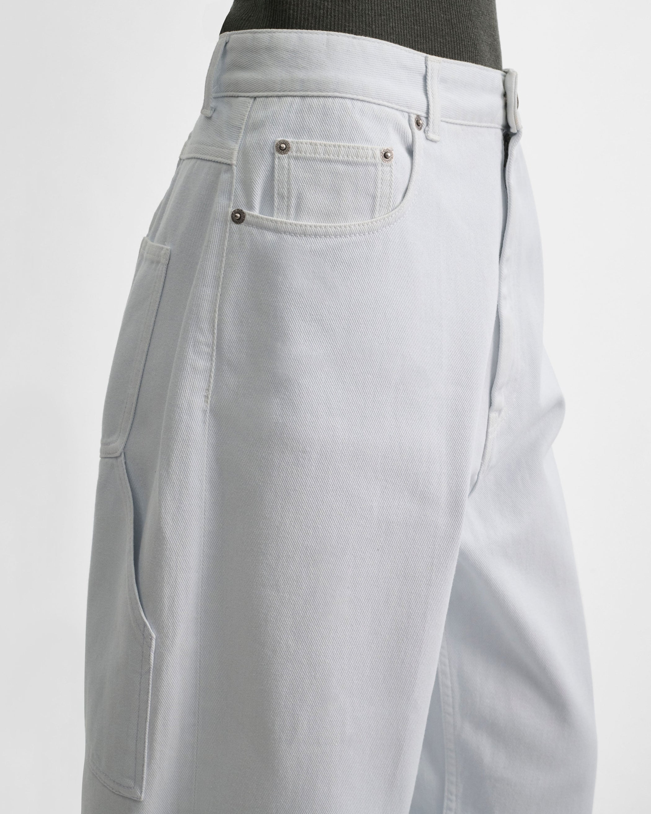 Close up detail view of model wearing RELAXED ZIP JEANS in pale ice blue cotton