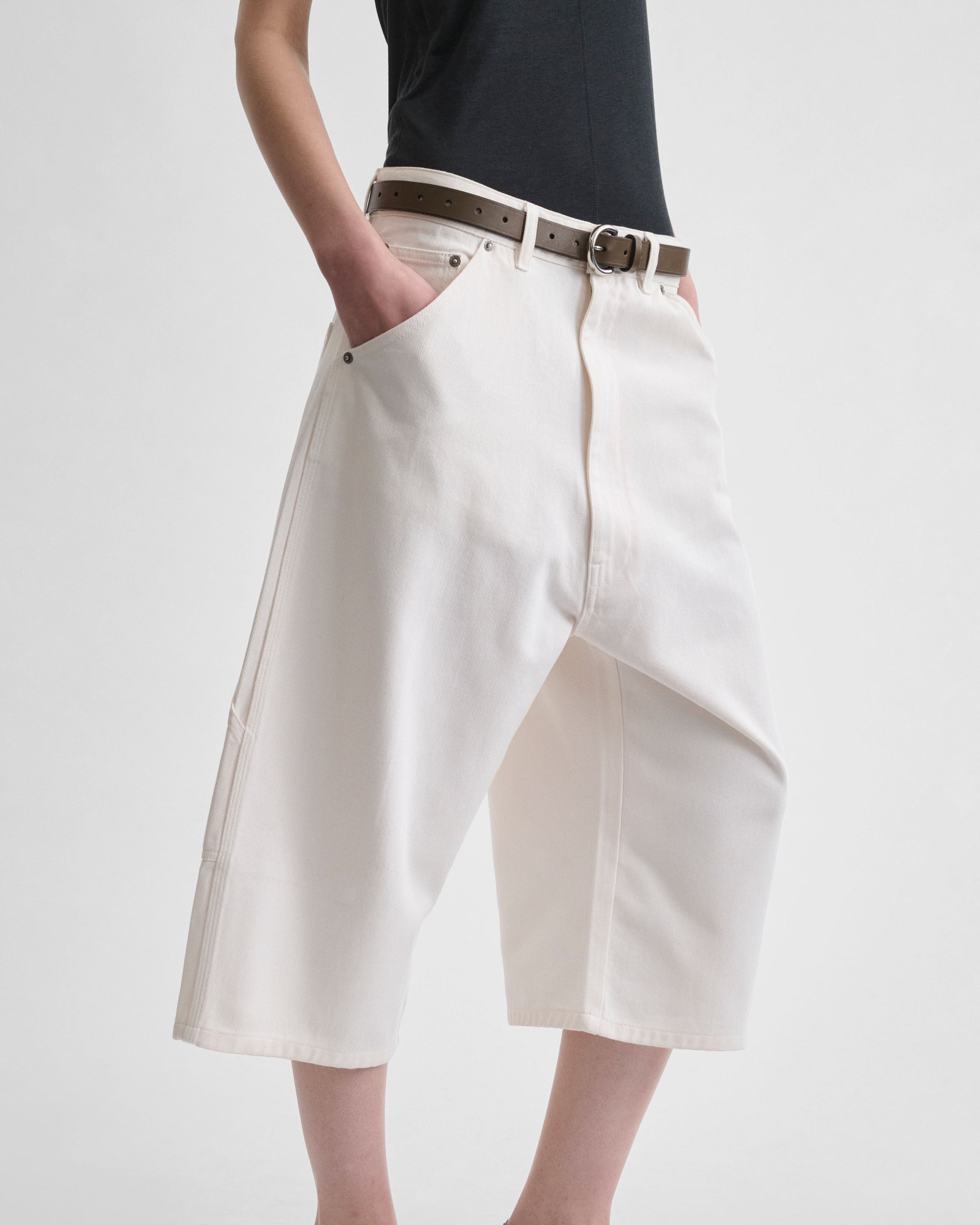 Angled side view of model wearing CARPENTER SHORTS in pale blush