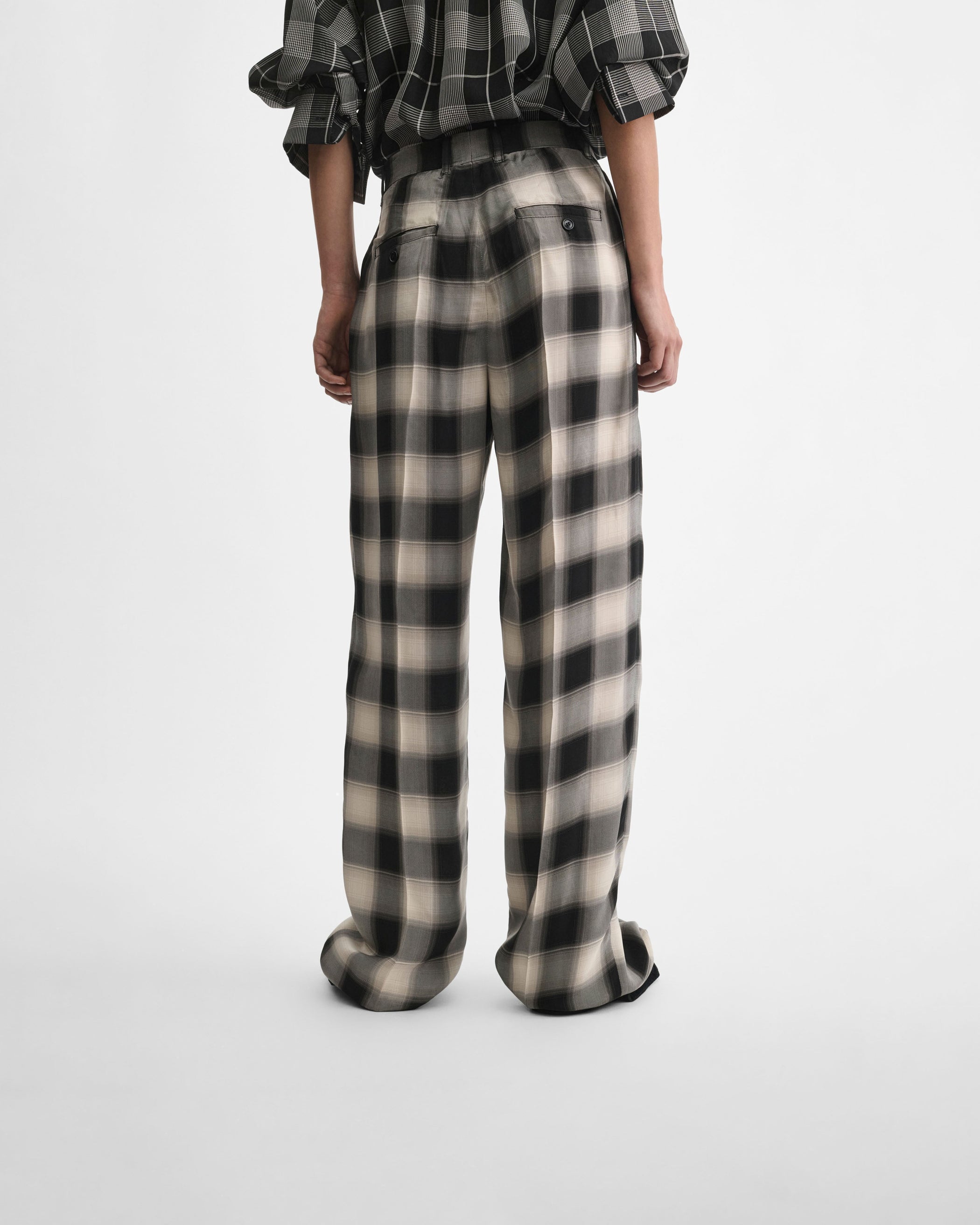 Back view of model wearing DOUBLE PLEAT TROUSERS in salt and pepper woven viscose