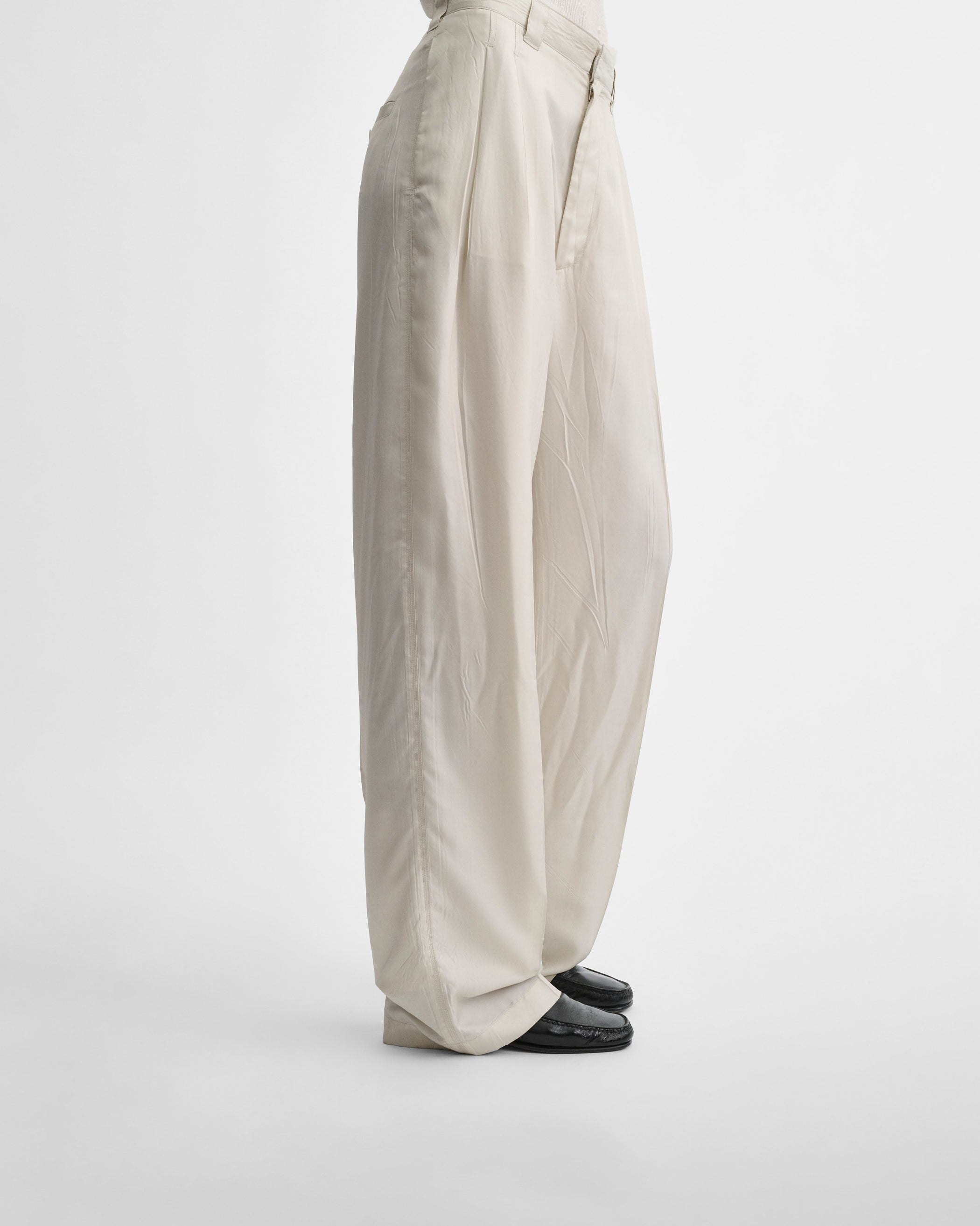 Side view of model wearing CHINO TROUSERS in salt technical twill