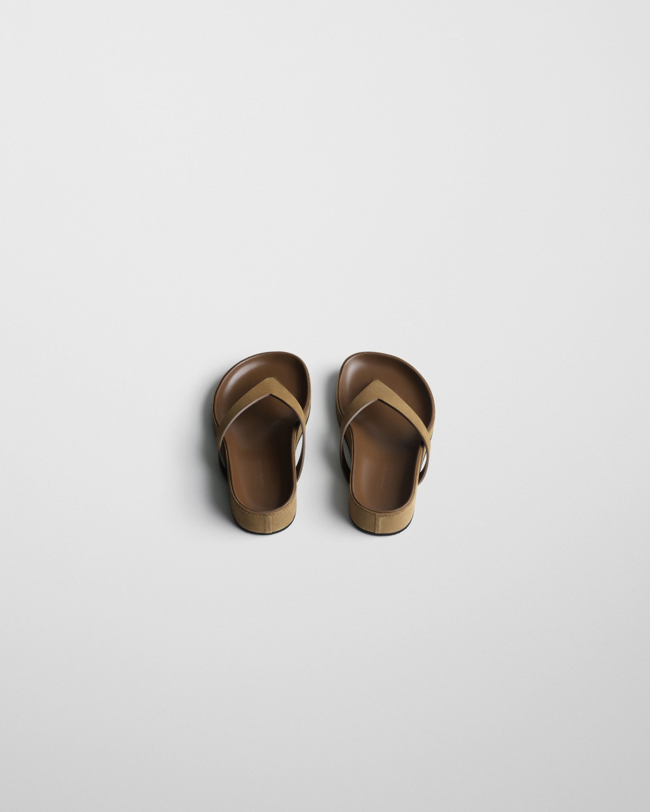 Angled top view of ROUND FLIP FLOP in caramel suede