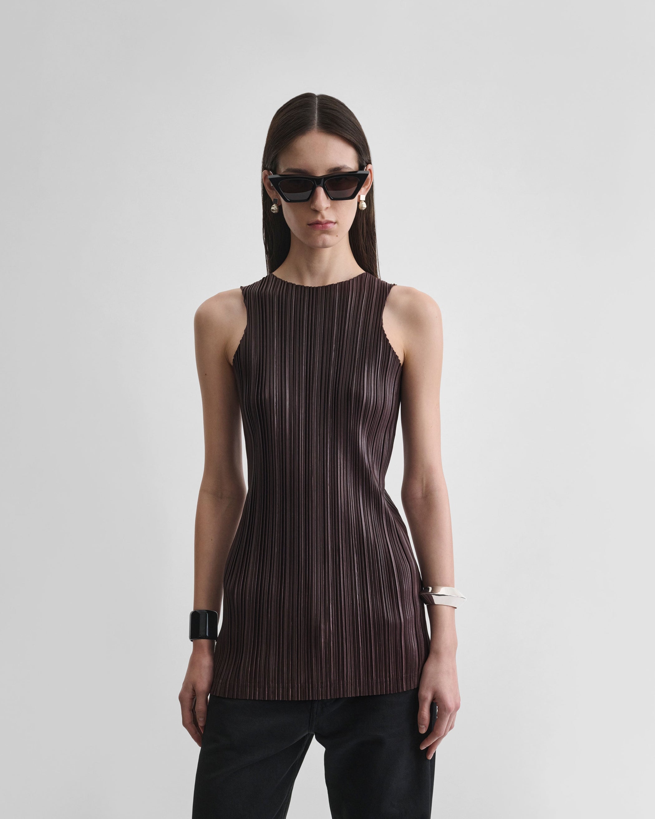 Front view of model wearing RAZOR PLEAT TANK in dark brown polyester