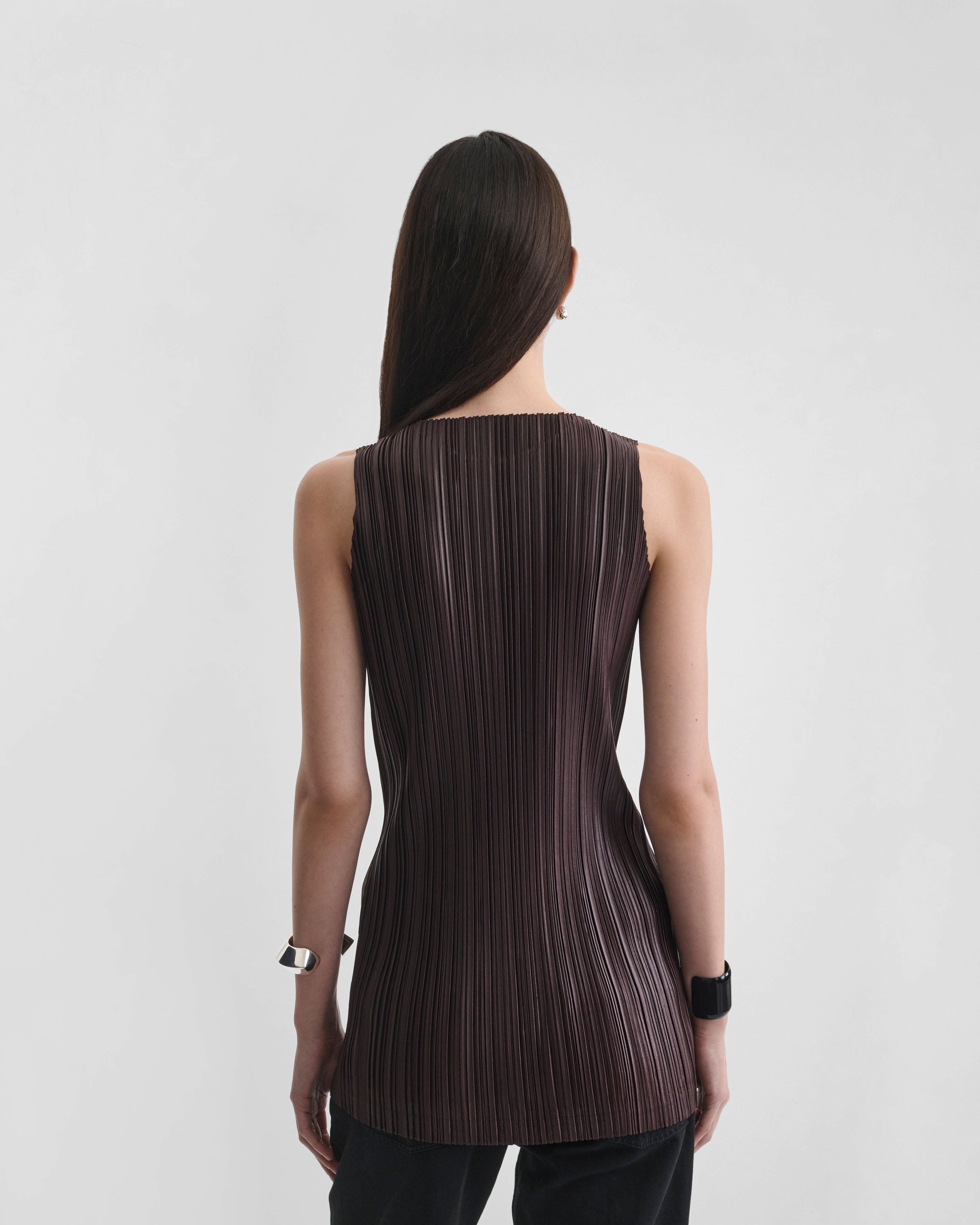 Back view of model wearing RAZOR PLEAT TANK in dark brown polyester
